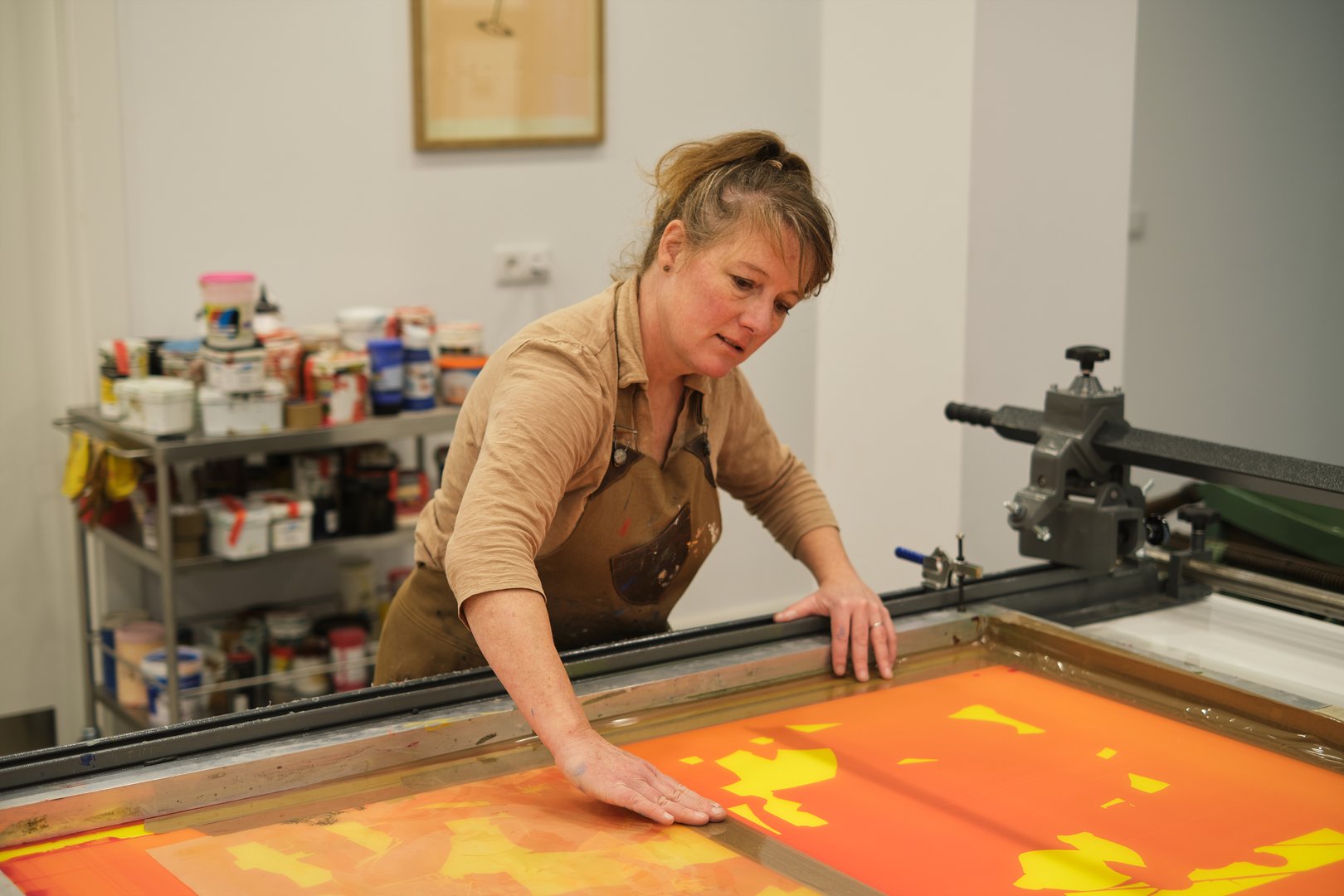 Concentrated female small business owner doing Screen printing in the studio
