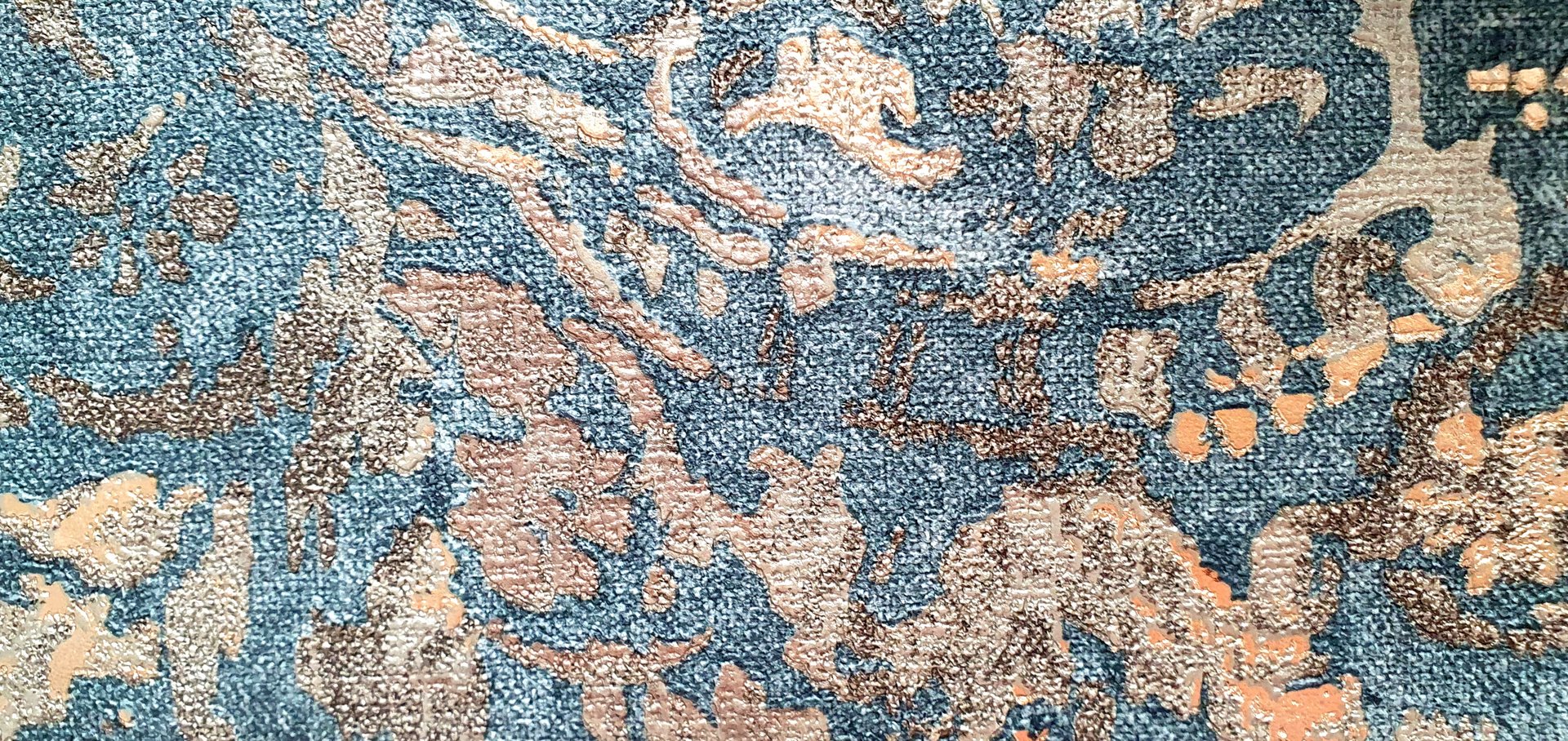 Abstract stains blue and gold texture of non-woven wallpaper. Vintage ornament with sea gold, jacquard. Interior design, wallpaper, upholstery, carpet.