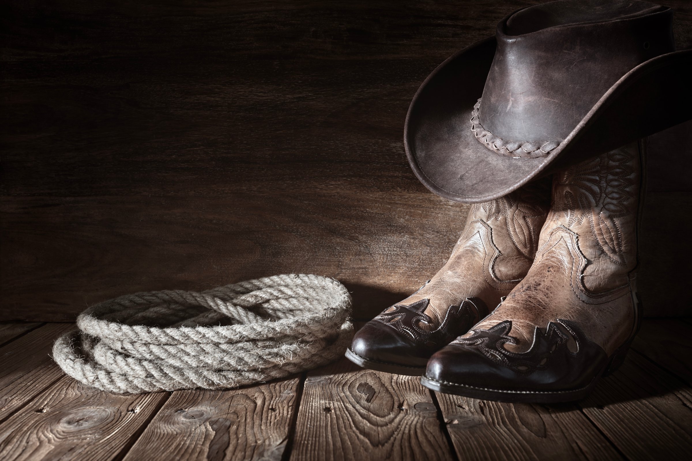 Cowboy boots and hat background with copy space for country music festival, line dancing or wanted advert copy