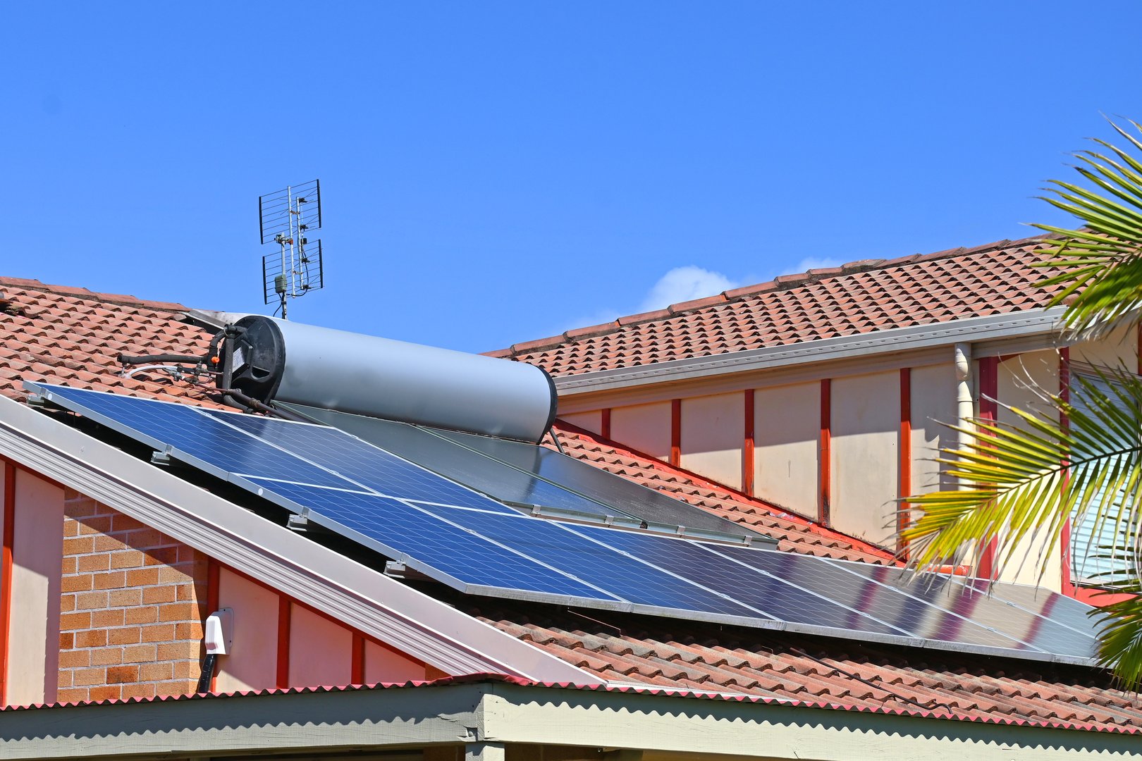 Solar electric panels with a solar hot water heater on a house roof