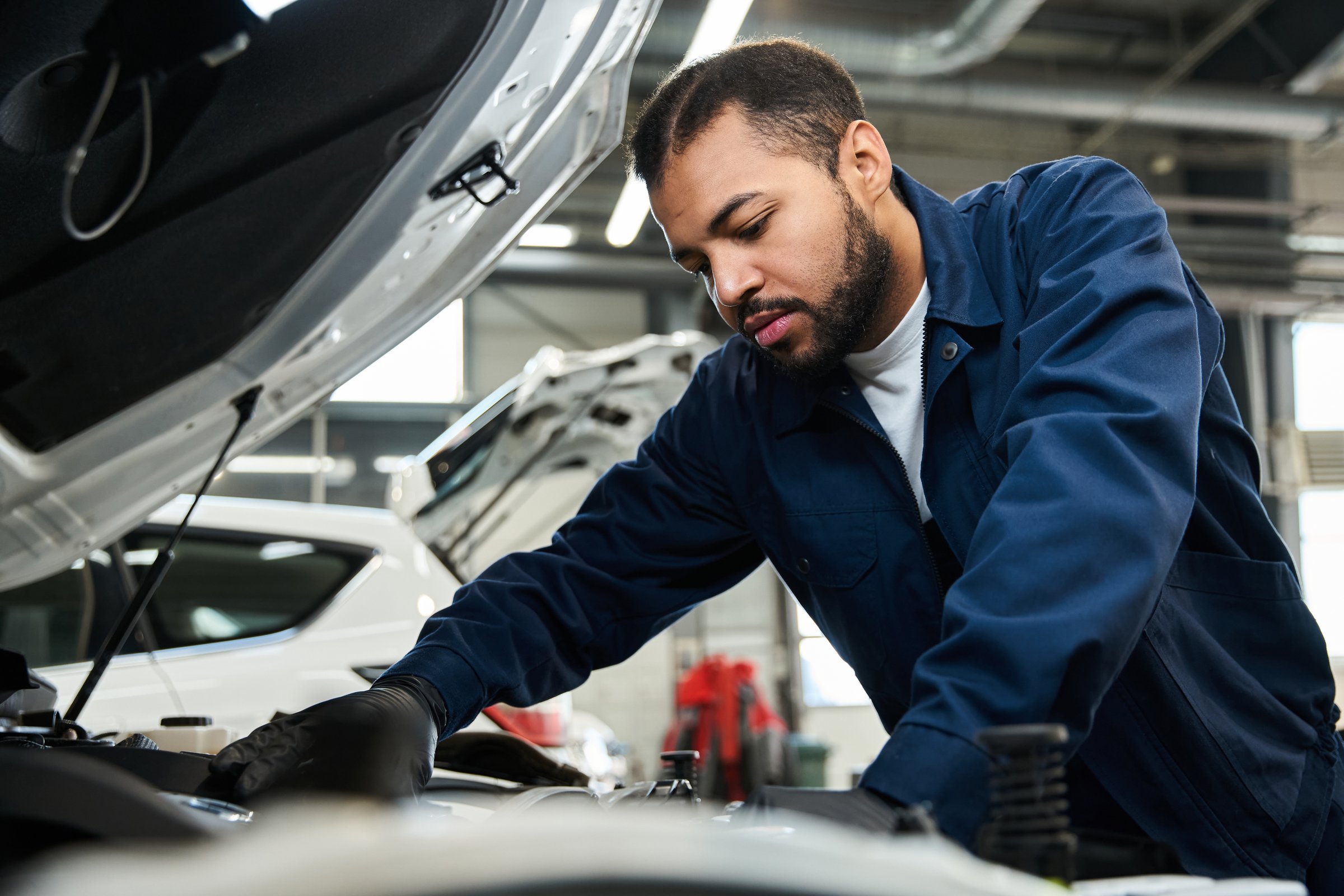 Skilled mechanic works diligently under the hood for vehicle repair and maintenance tasks.