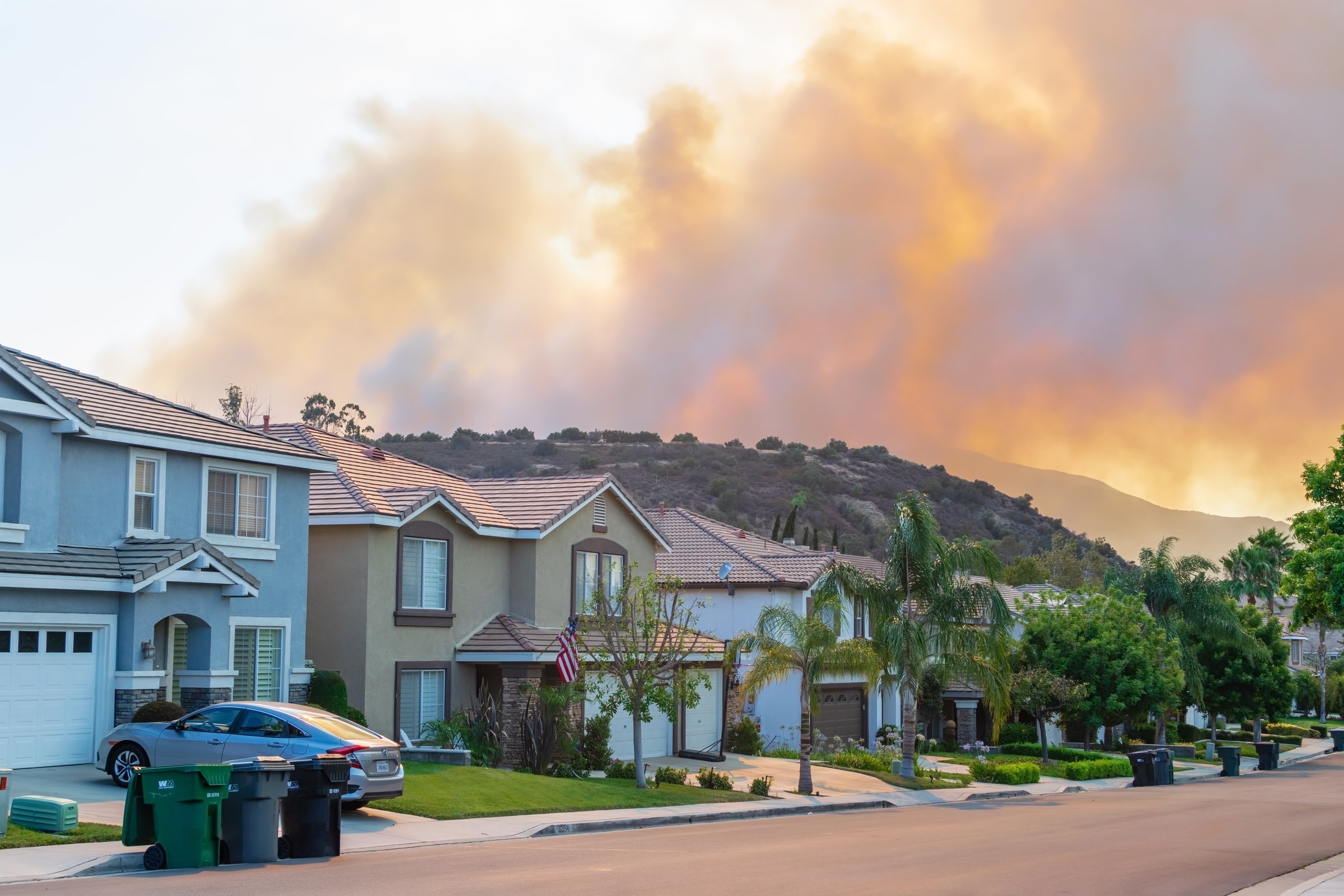 Corona, CA USA - July 19, 2018: A wildfire burns and smoke rises in the forest near homes on the south city border close to the Cleveland National Forest.