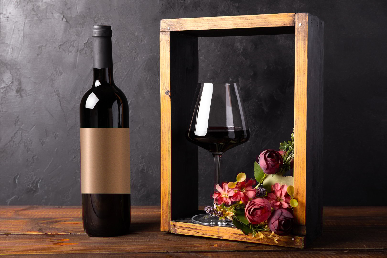 Bottle and a glass of red wine with flowers. Minimalistic composition with black background for product branding, identity, and packaging