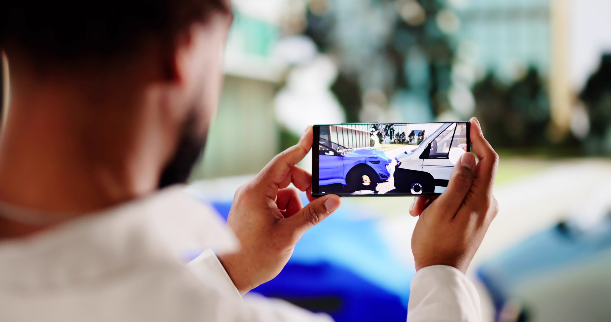 African American businessman taking photos of car for insurance claim.