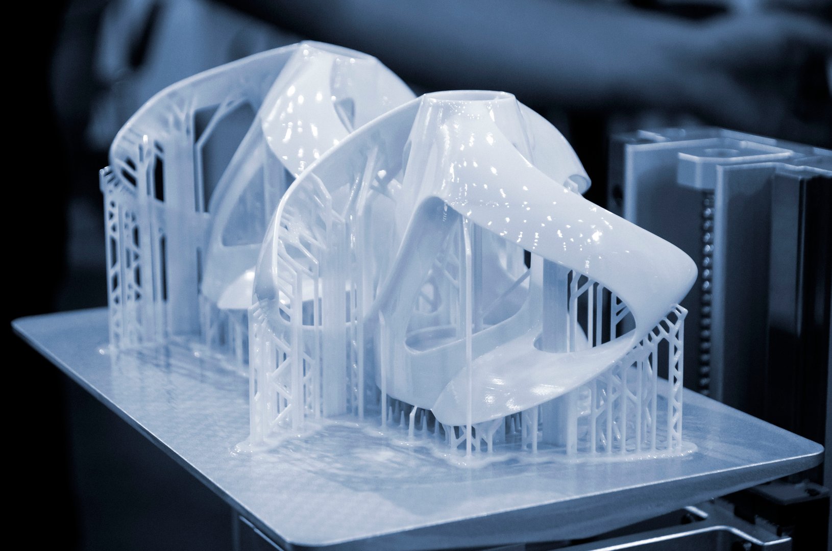 Printed models on 3D printer close-up. Objects printed on photopolymer sla 3D printer from liquid photopolymer resins on printing platform. Modern progressive additive technology. 3D printer printing