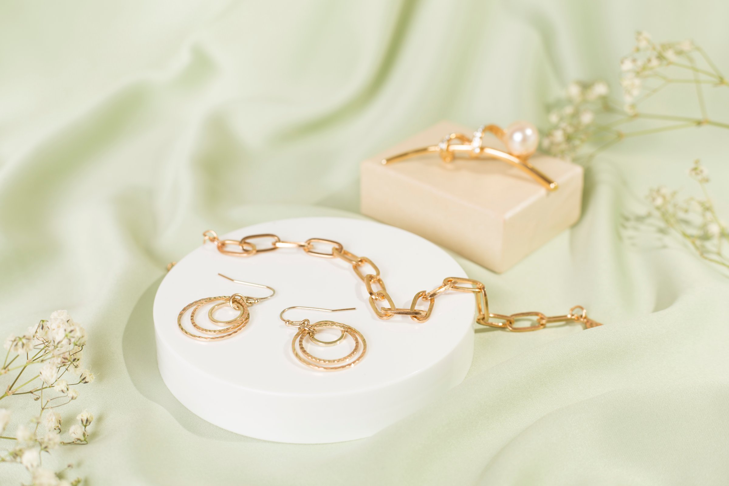 Elegant golden jewelry with decoration on color background