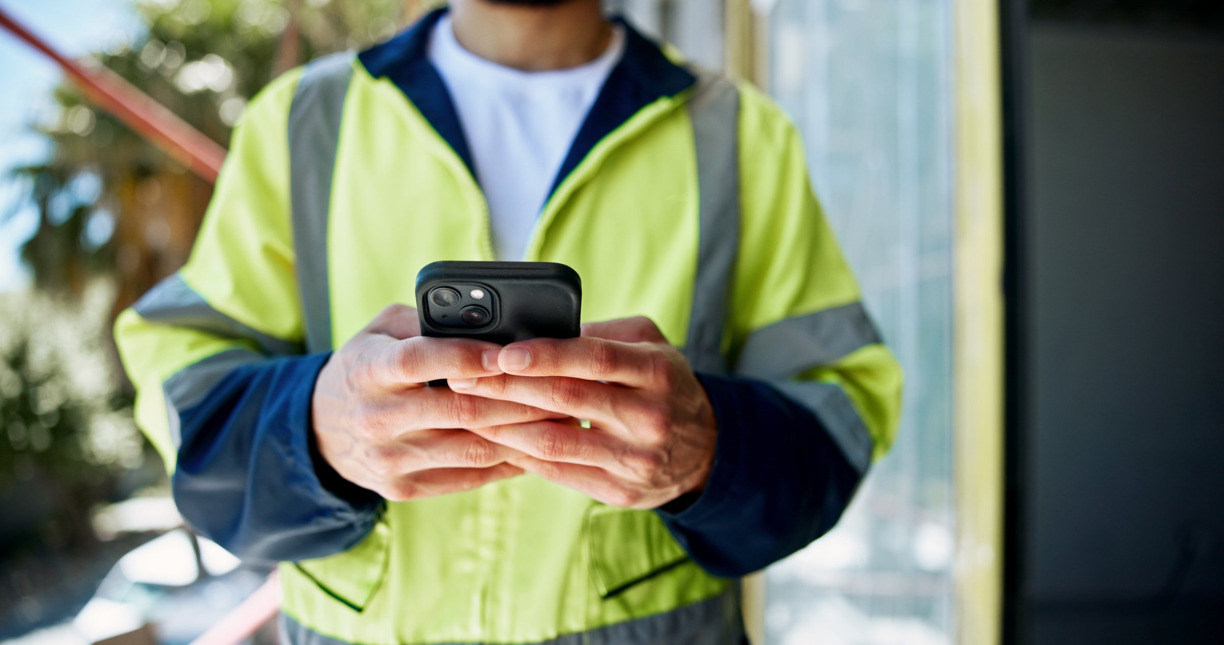 Hands, phone and construction worker with texting, person or contact with info for building development. Engineer, smartphone and check with network, notification or email on mobile app at property