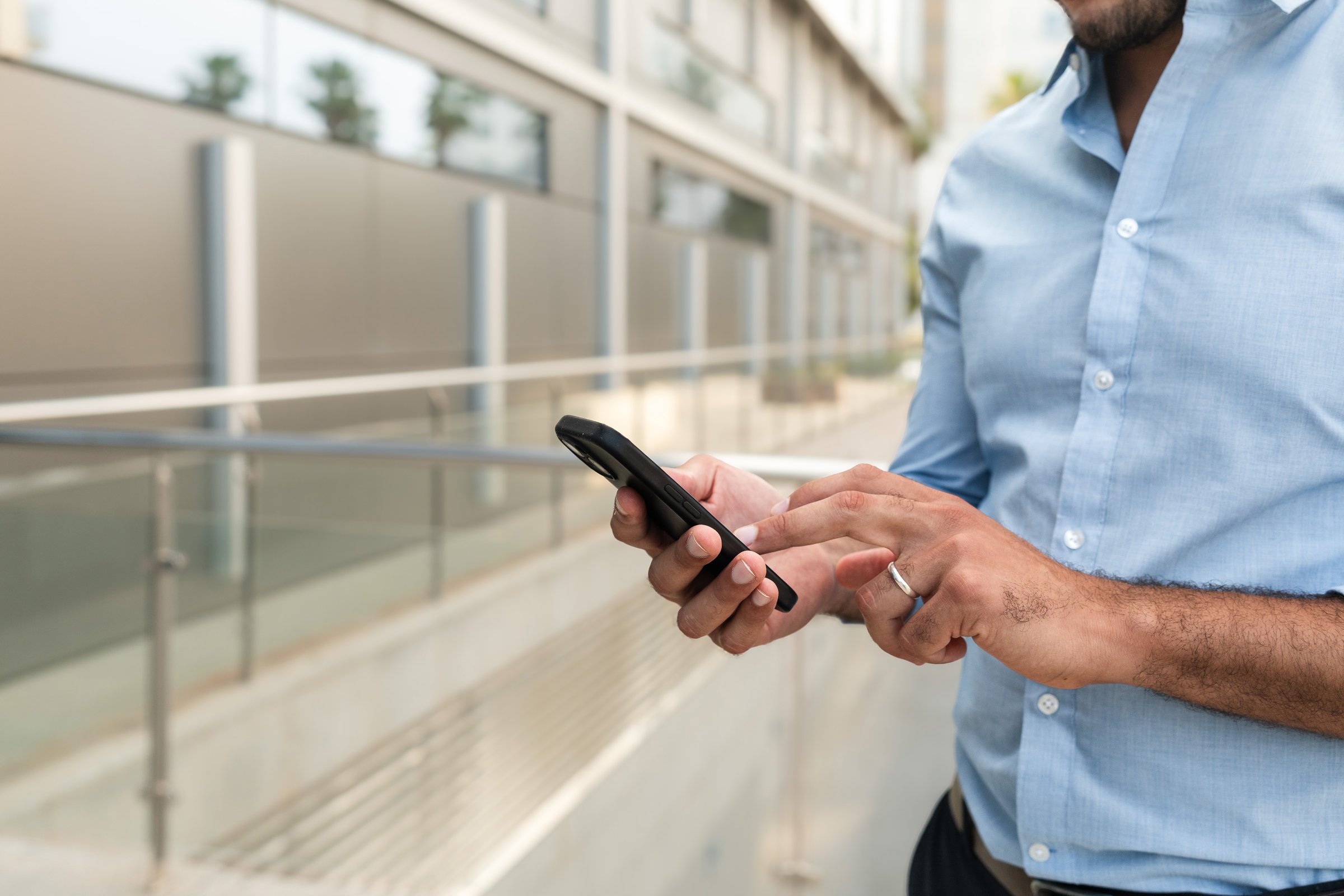 Close up of Businessman using smartphone app outside office building