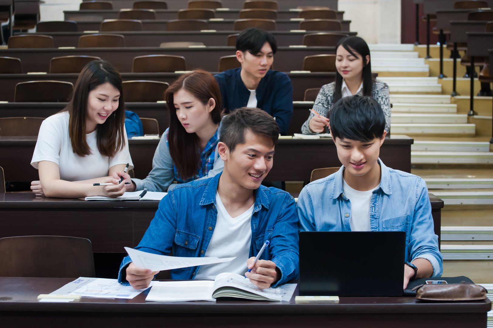 Students listening to lecture and taking notes in auditorium