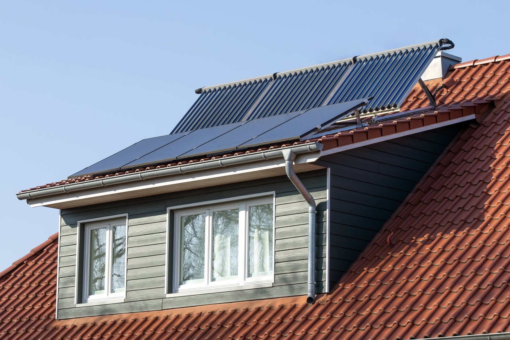 solar modules and vacuum tube collectors on the dormer of a house