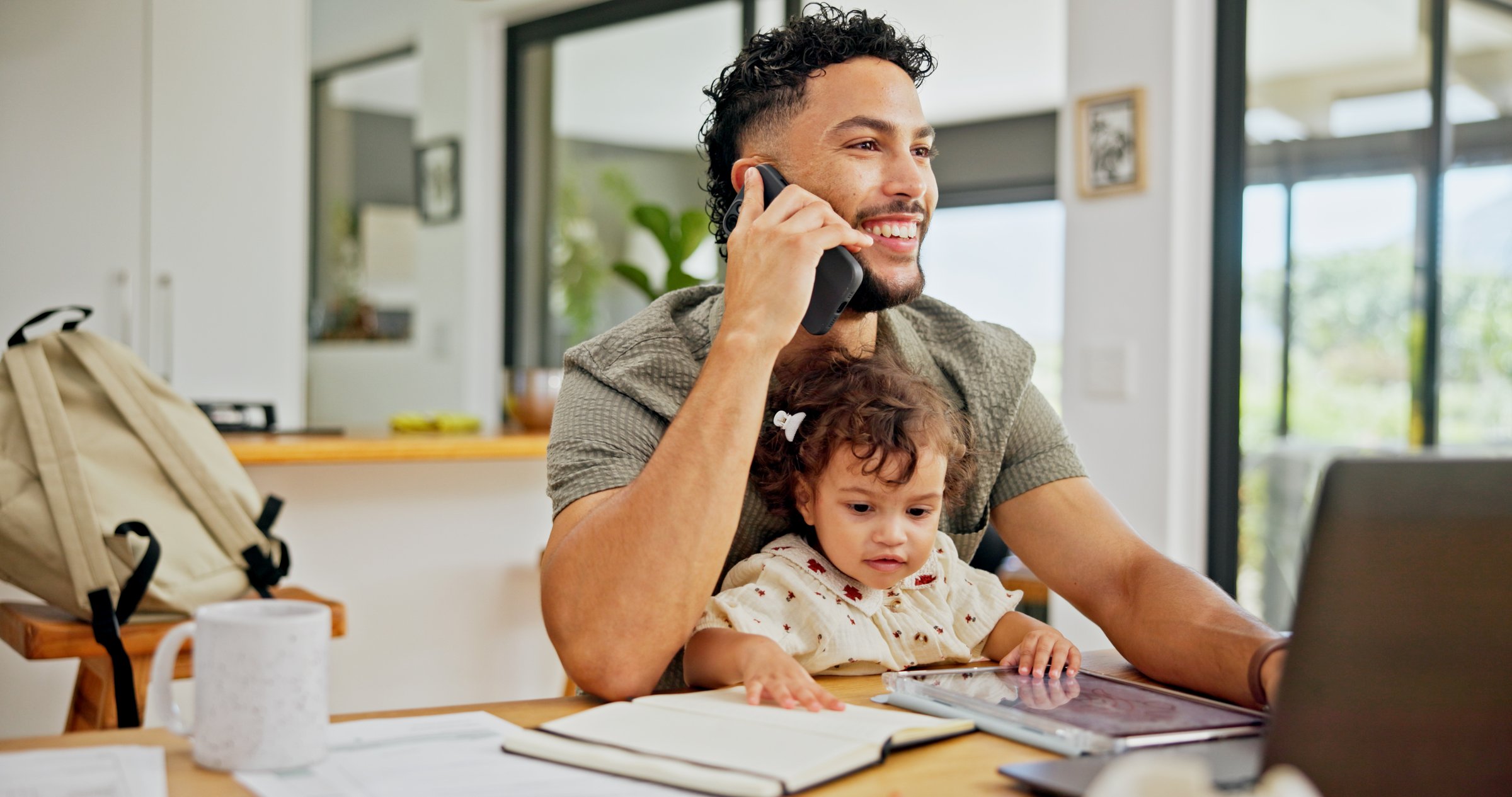 Happy, baby or dad with phone call or laptop for remote work, freelance or business in home. Talking, single parent or father juggling parenting task for project deadline, planning or multitasking