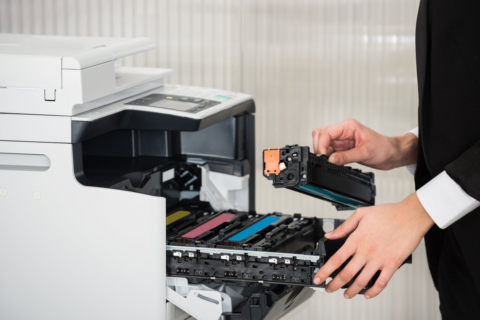 Midsection of young businessman fixing cartridge in printer machine at office