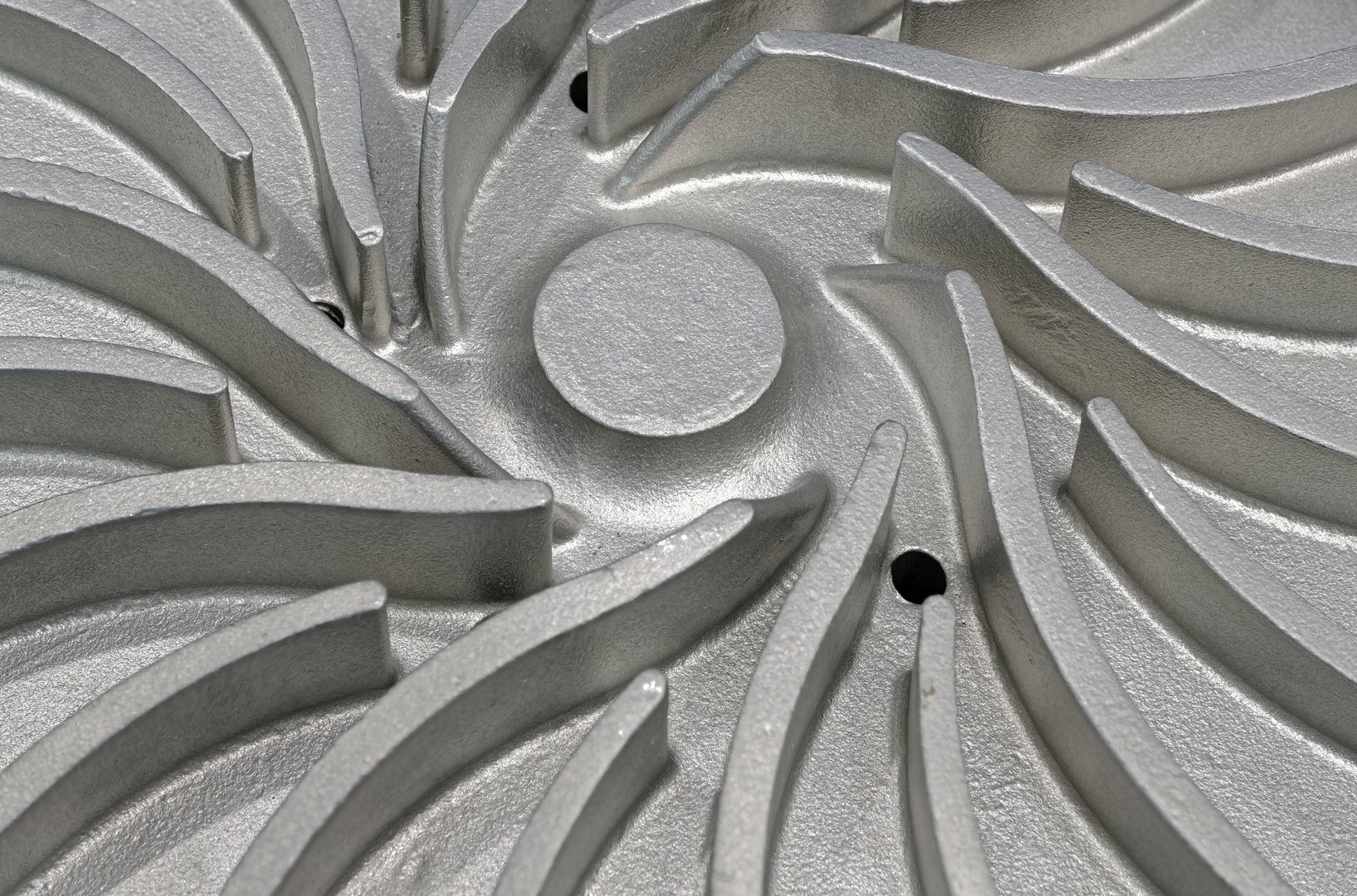Aluminium centrifugal pump impeller, close up shot, selective focus, abstract industrial background.