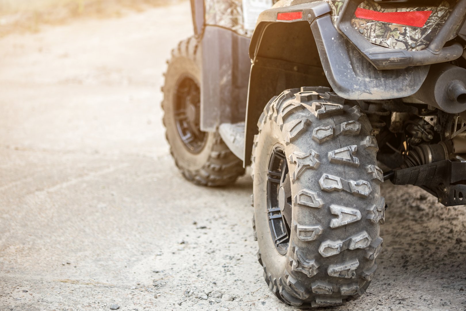 Close-up tail view of ATV quad bike. Dirty whell of AWD all-terrain vehicle. Travel and adventure concept.Copyspace.Toned.