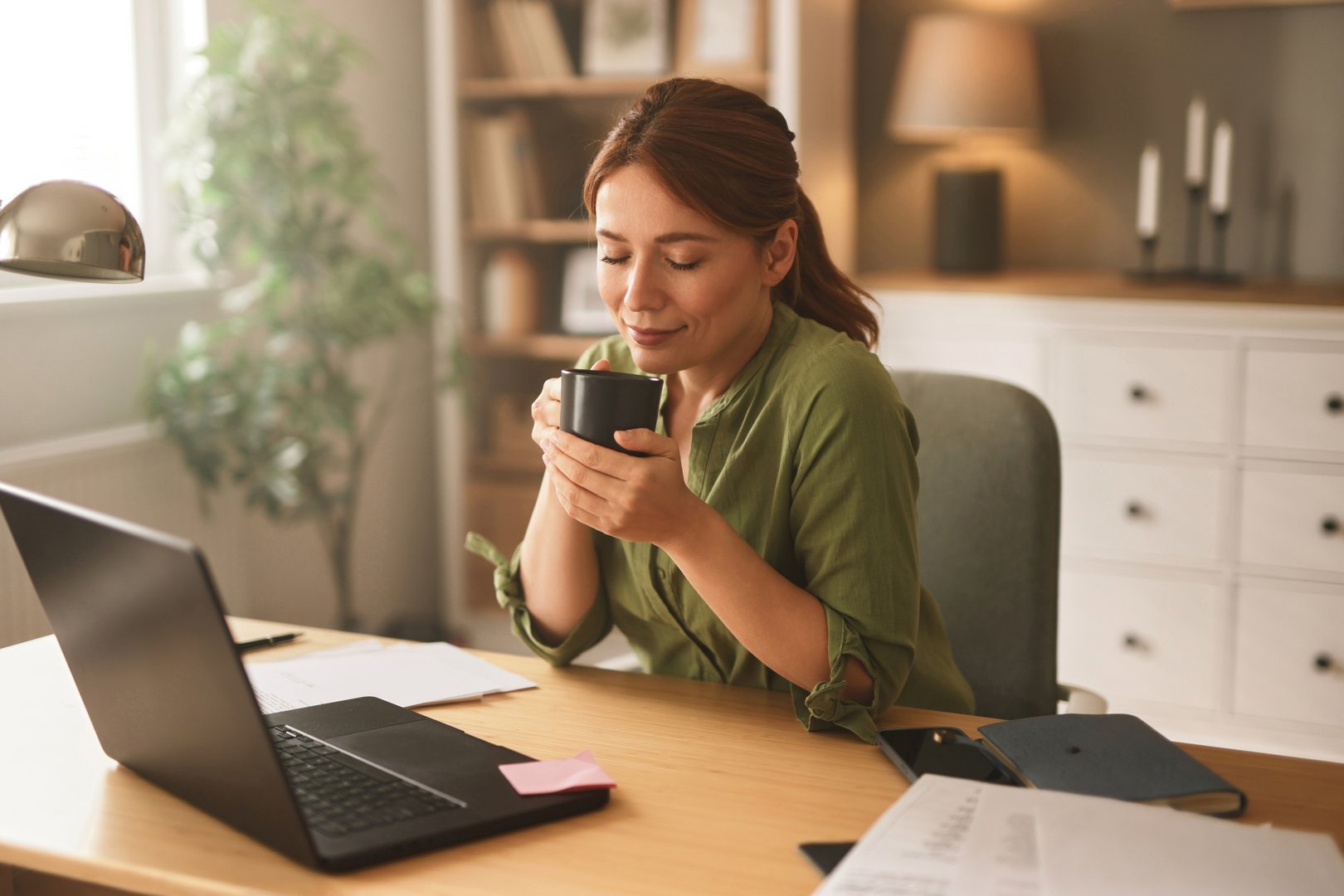 Serene businesswoman savoring a coffee break during her productive home office workday