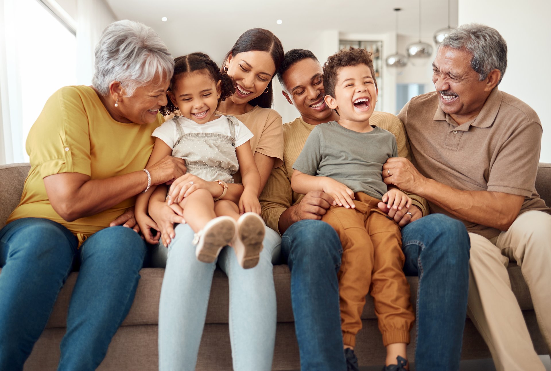 Happy family sitting on sofa together laughing and bonding