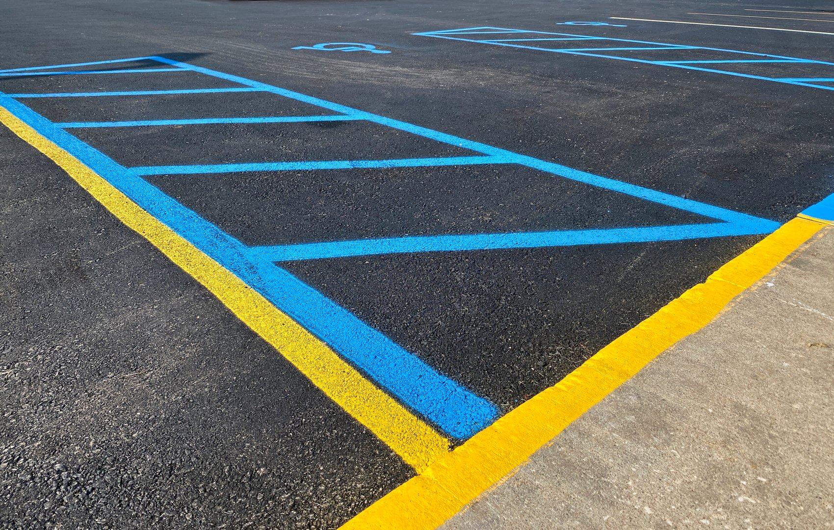 Freshly painted parking lot with an accessible loading zone with blue lines