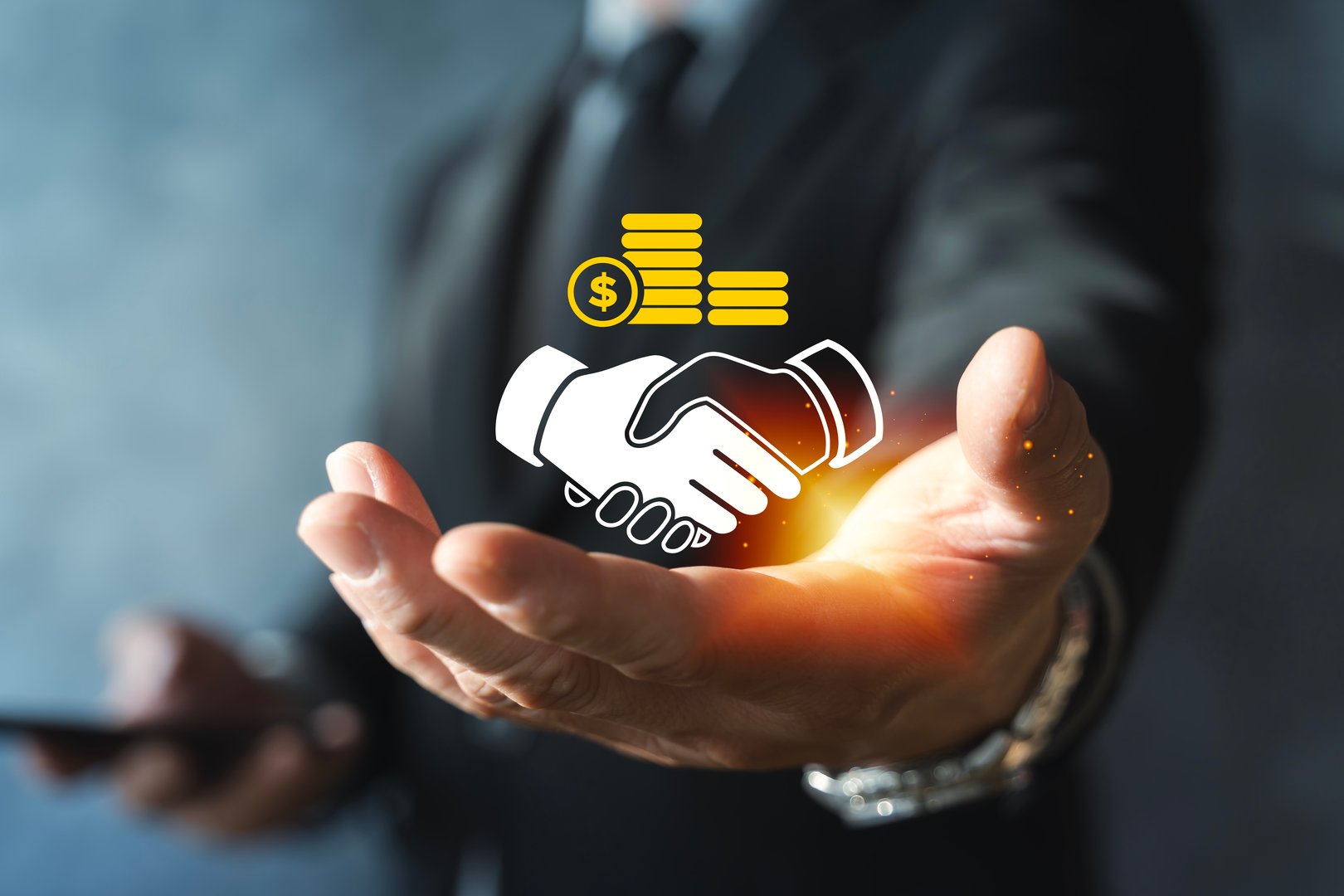 Businessman holding glowing handshake and coin stack icon