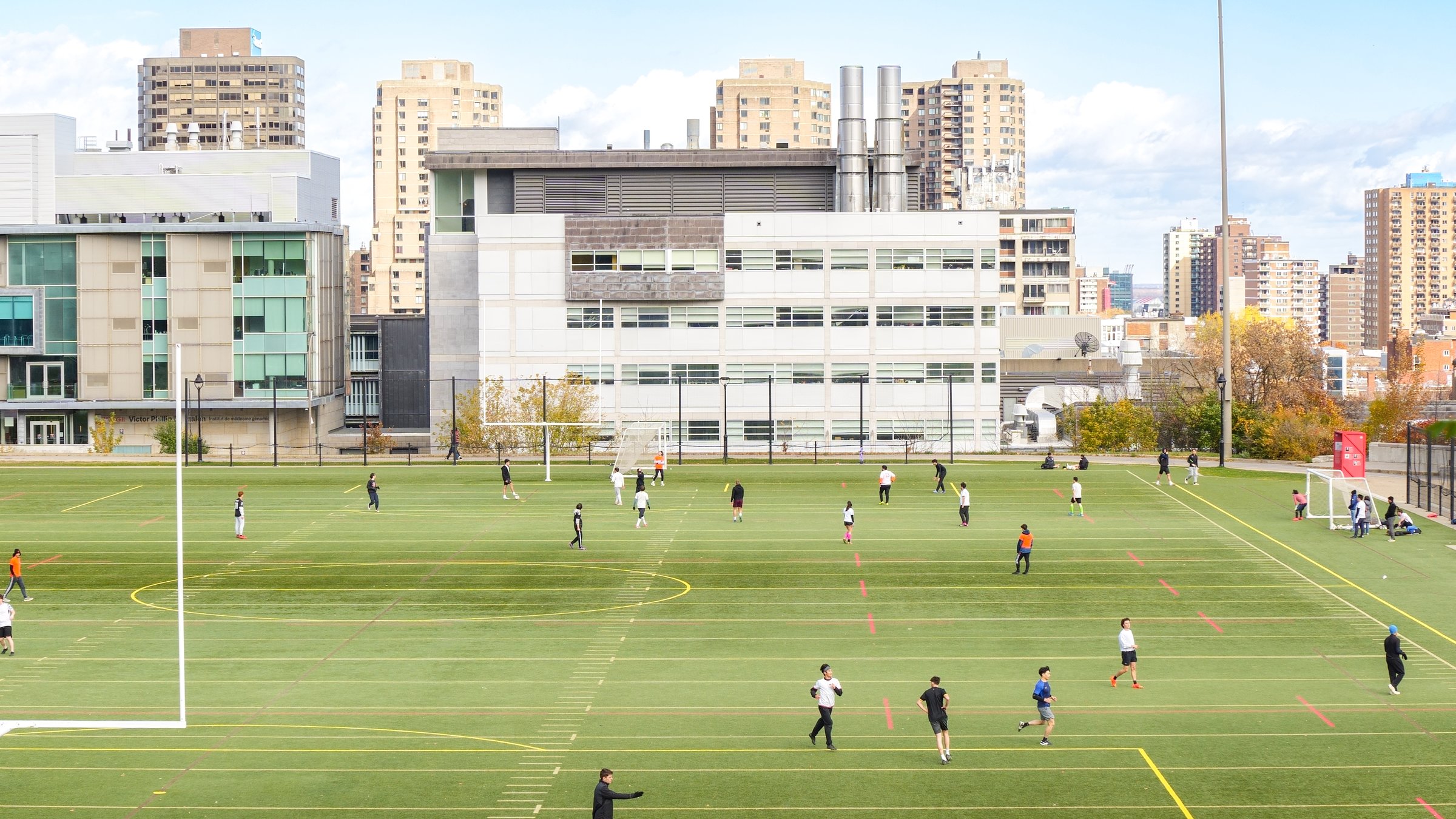 Montreal, Quebec Canada - Oct 27 2024: McGill university Students playing soccer on a university campus with modern buildings in the background.