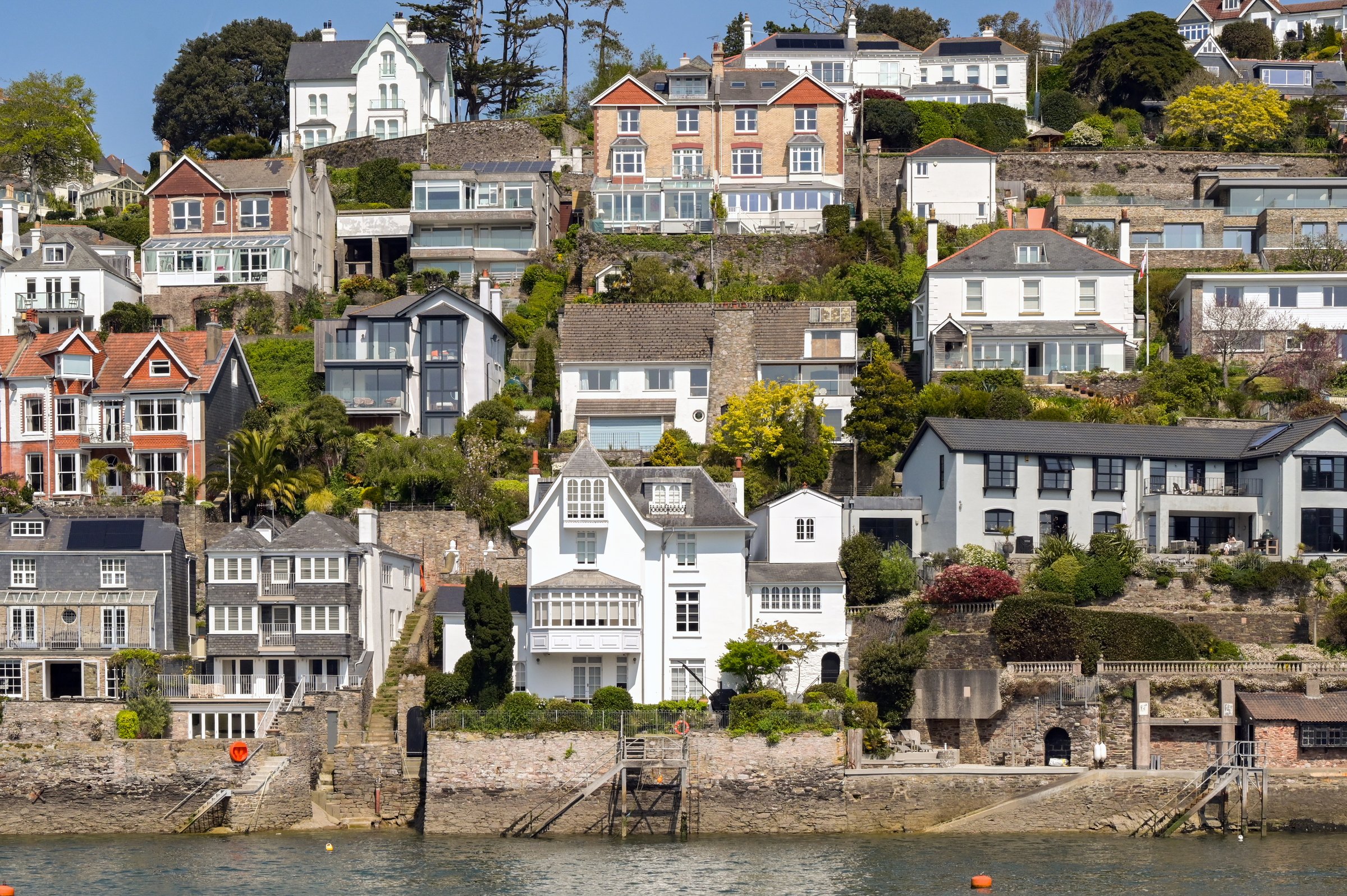 Dartmouth, Devon, England, UK - 24 April 2025: Scenic view of houses on the waterfront of the town of Dartmouth