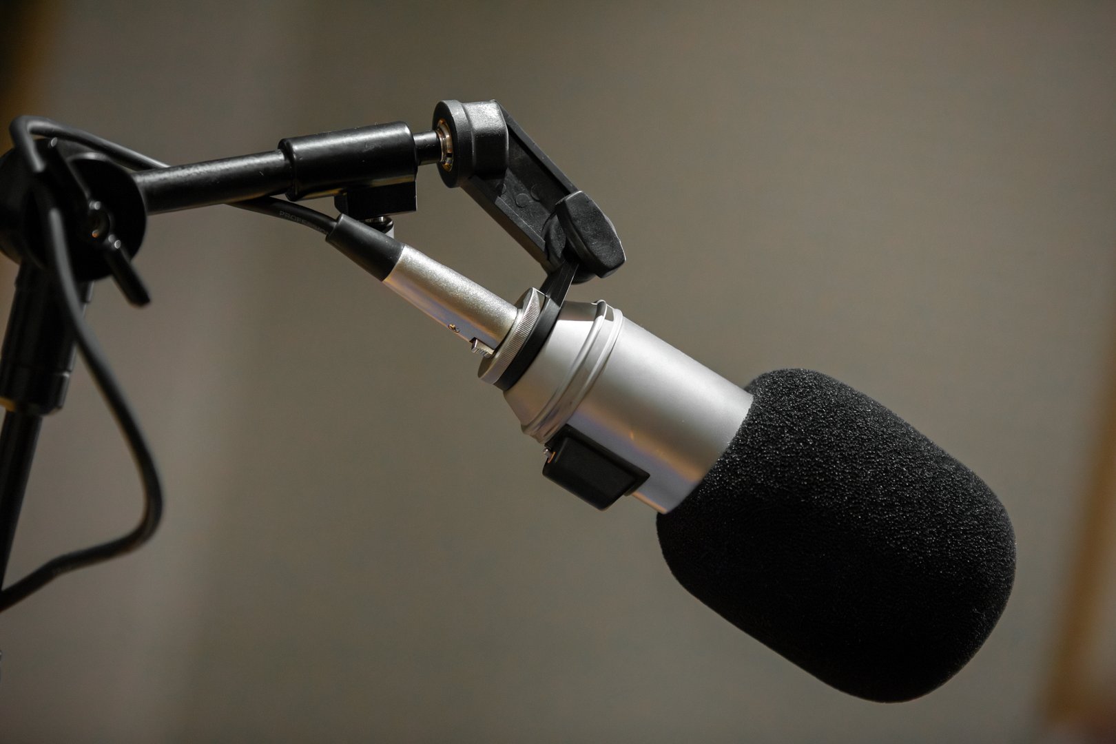 A professional microphone is set up in a sound studio, designed for high-quality recording. The setting is calm and focused, ideal for music or voice capture.