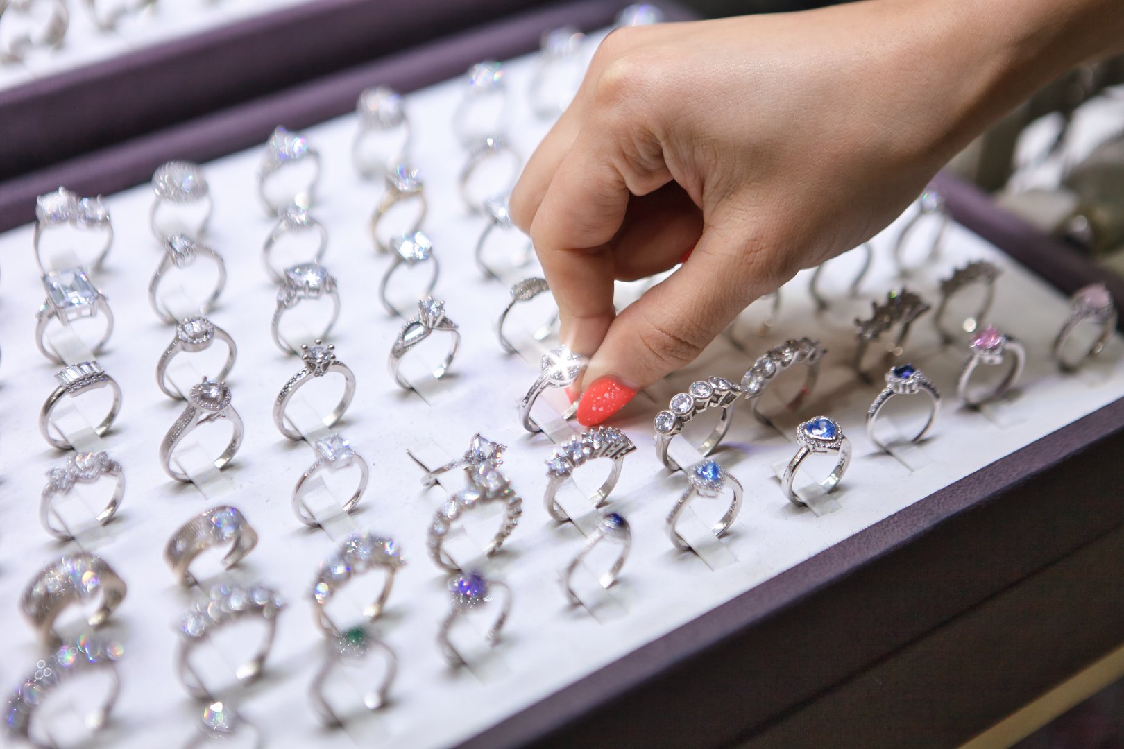 The woman picking a diamond ring at jewellery store, close-up.