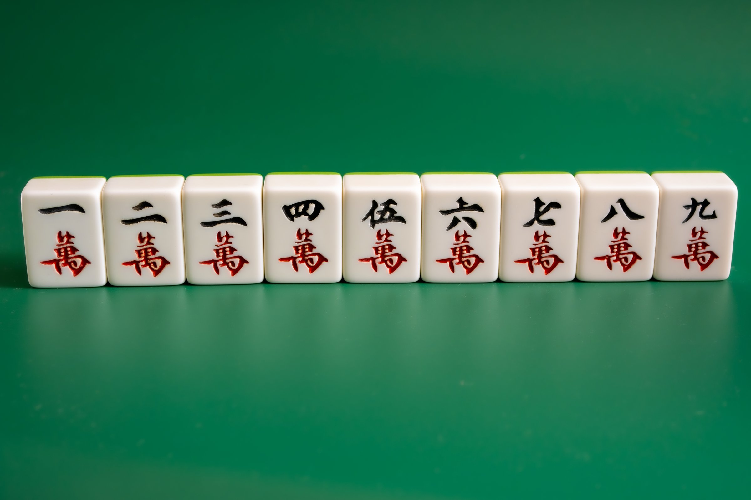 Qingdao,China-Apr.30.2025:Close-up of mahjong tiles on a green surface,Mahjong (mah jongg, mah-jongg, and mahjongg) is a tile-based game that was developed in the 19th century in China