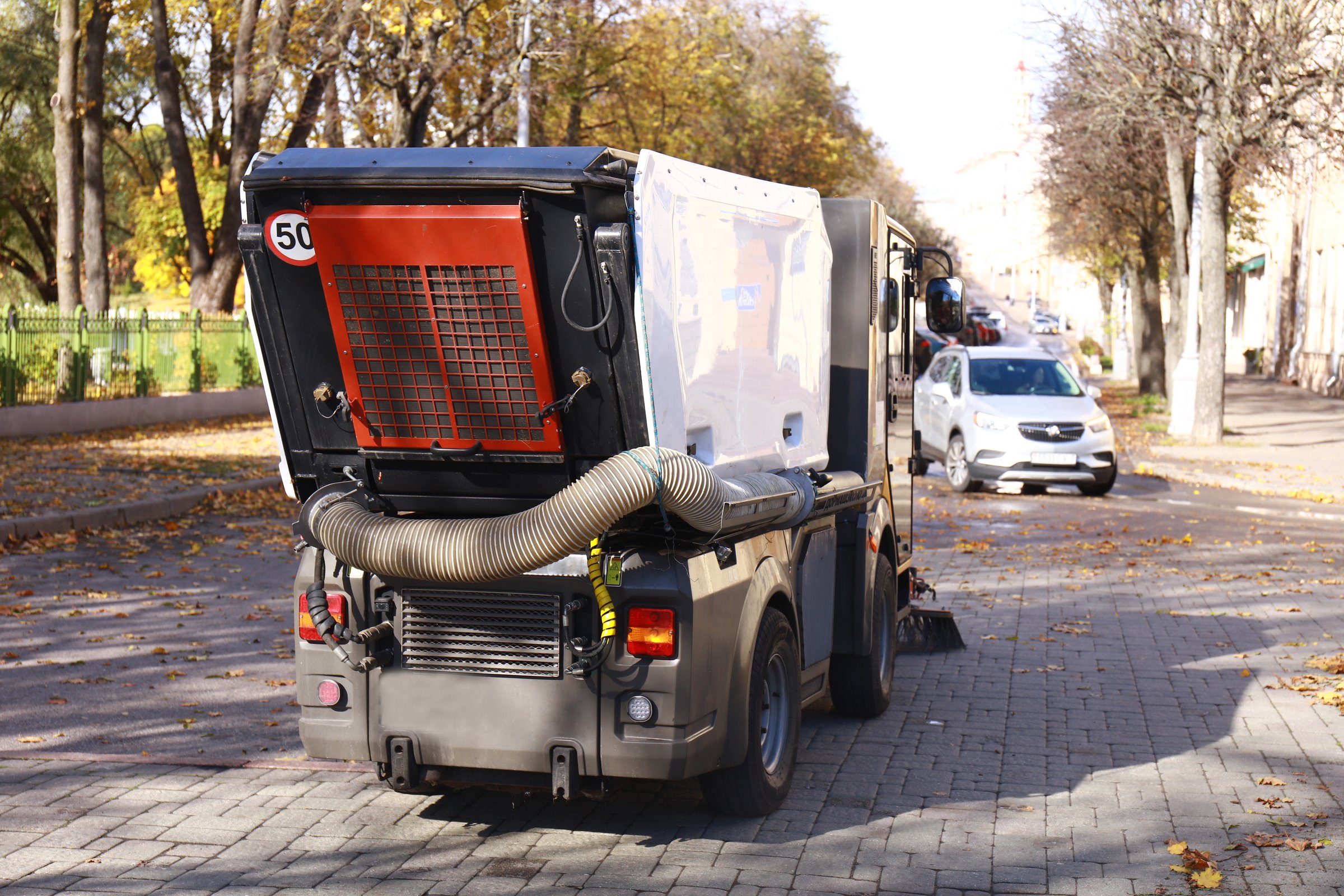 a street cleaning machine cleans the road from leaves