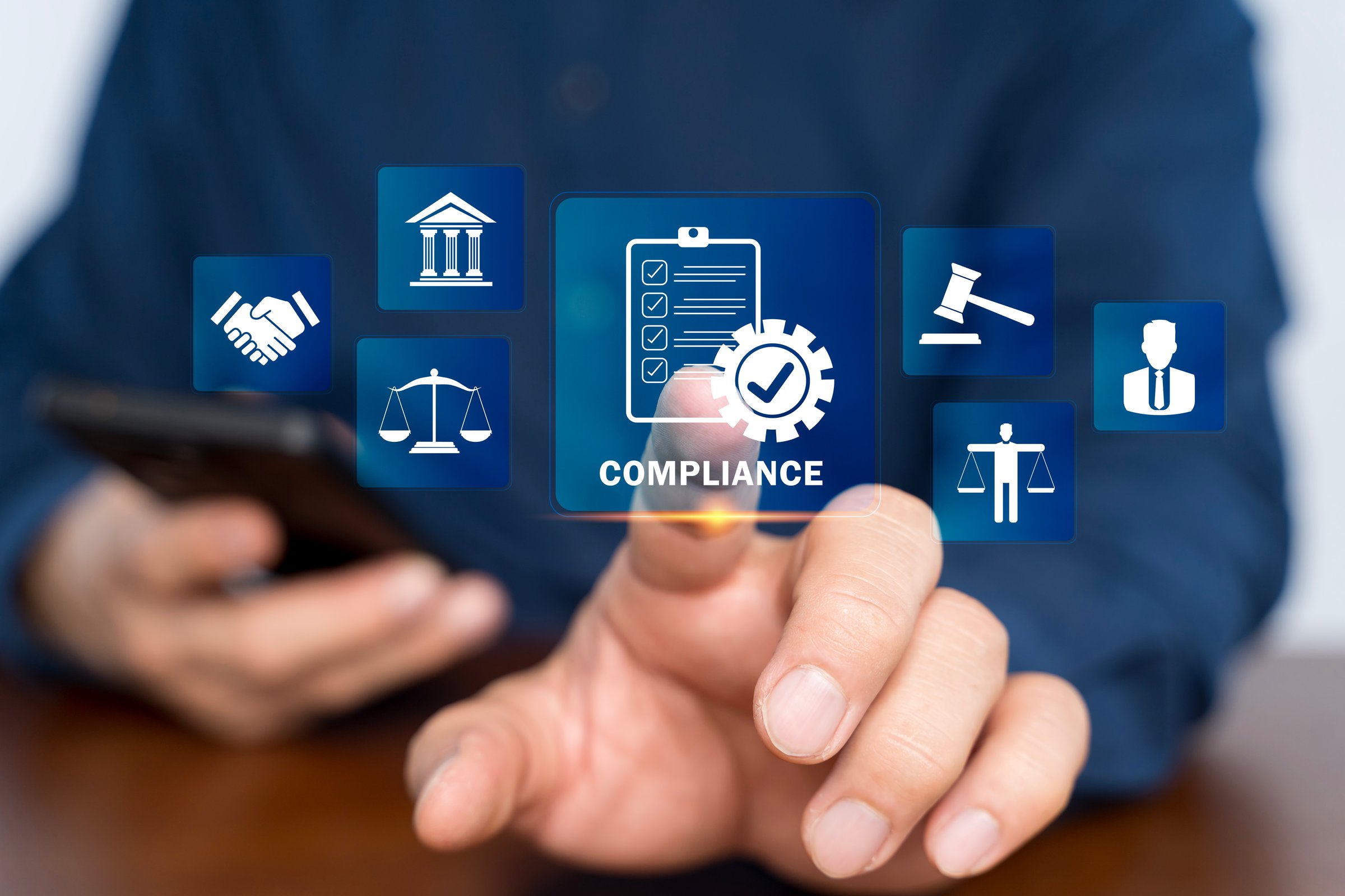 Compliance in business concept. Person use smartphone with compliance icon on virtual screen, ensuring the enforcement of laws, regulations, and standards. Stay in line with business policies.