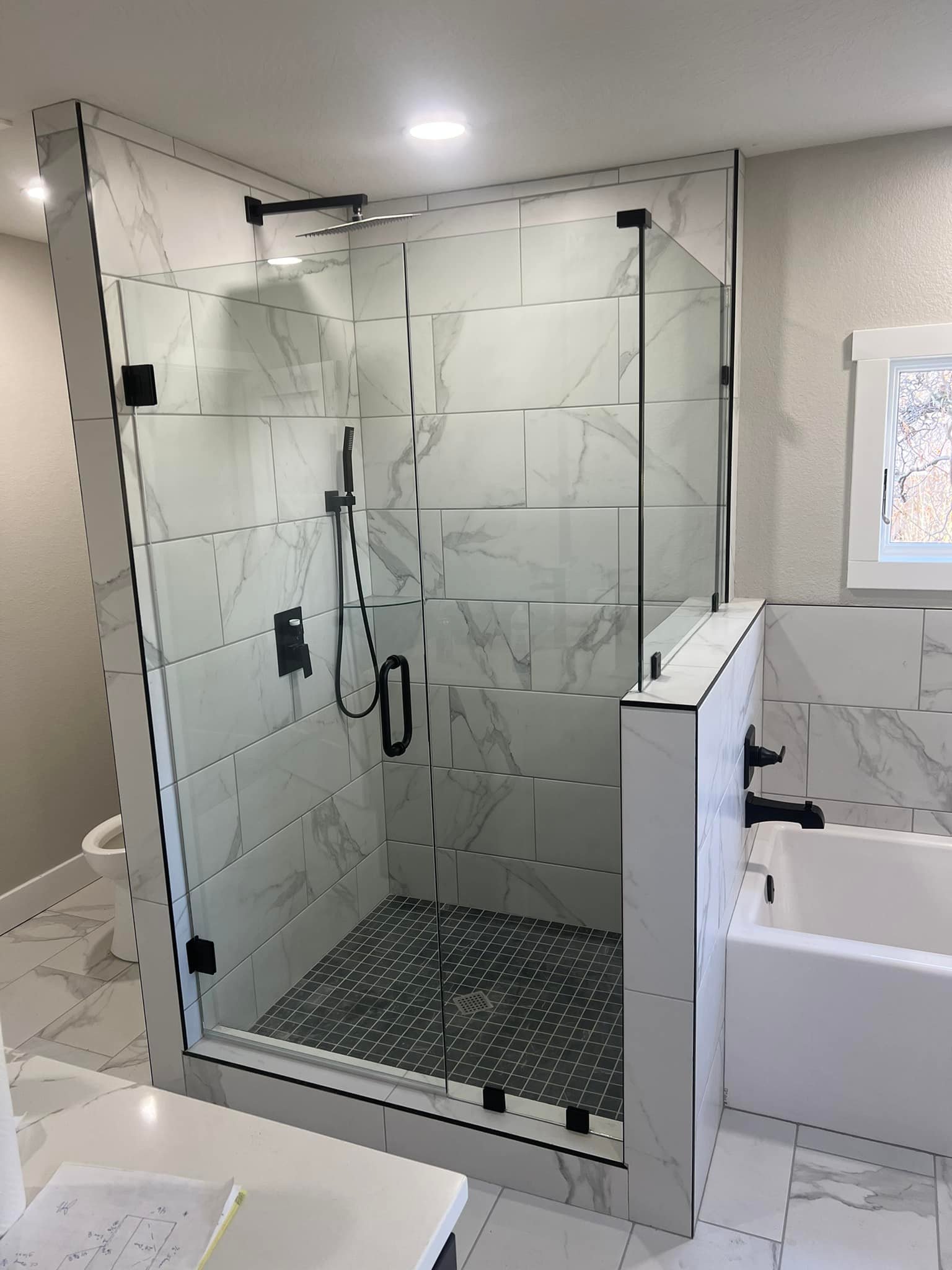 Semi frameless shower enclosure with matte black hardware