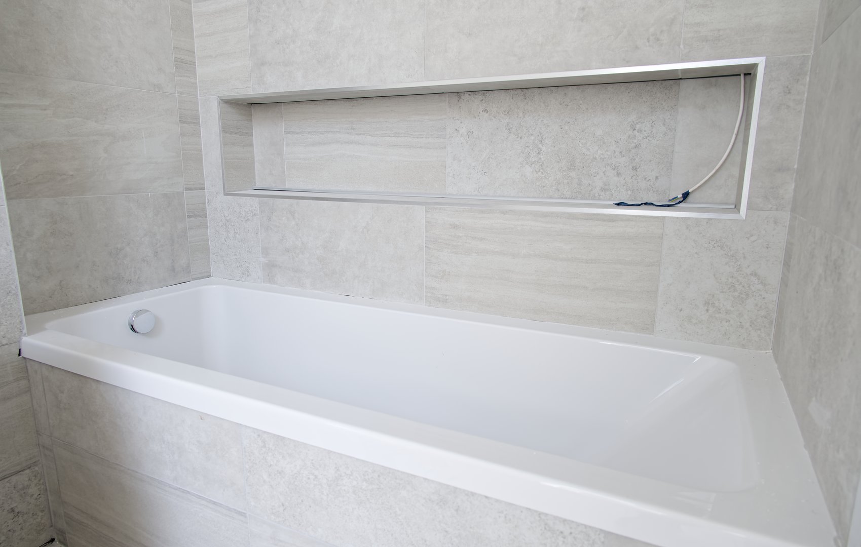 Clean white bathtub in regular bathroom