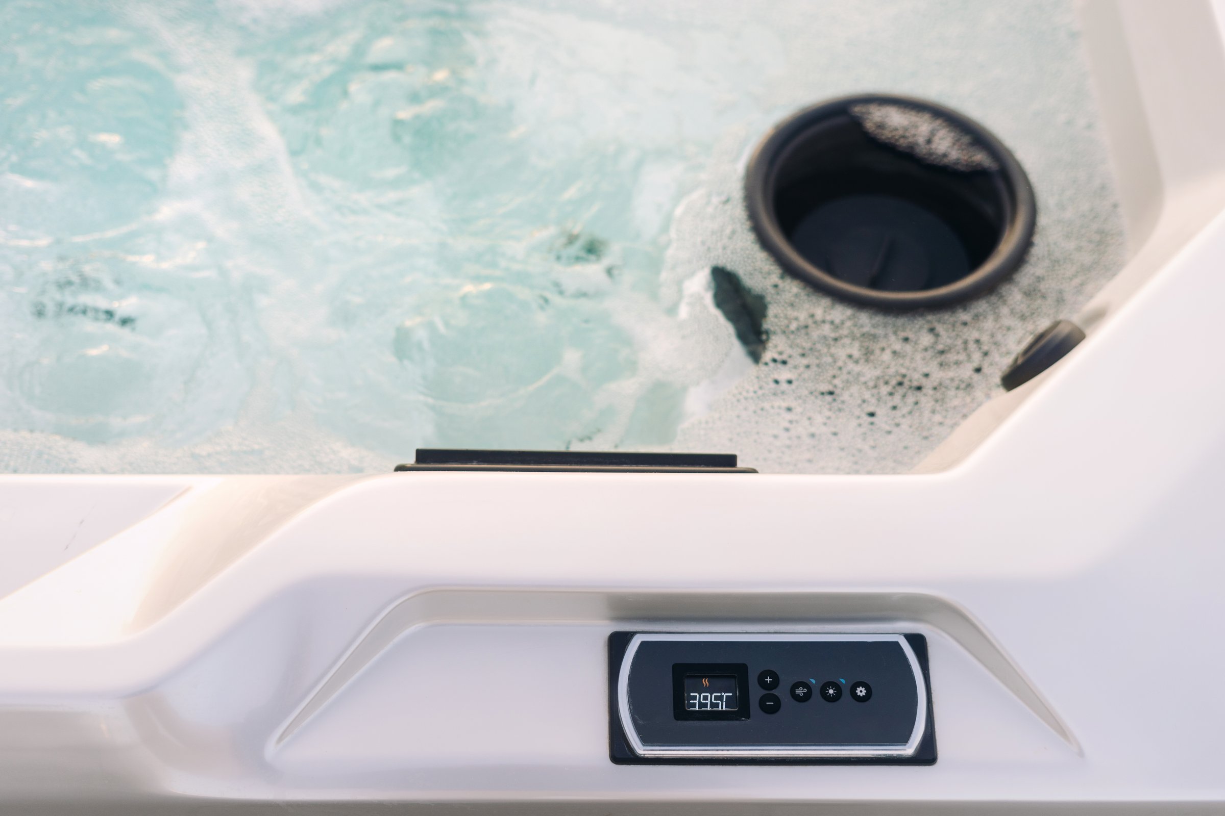 High angle view of hot tub with display and buttons for controlling temperature, water pressure and lighting. Flat lay of purification and filtration water system in bath with spa