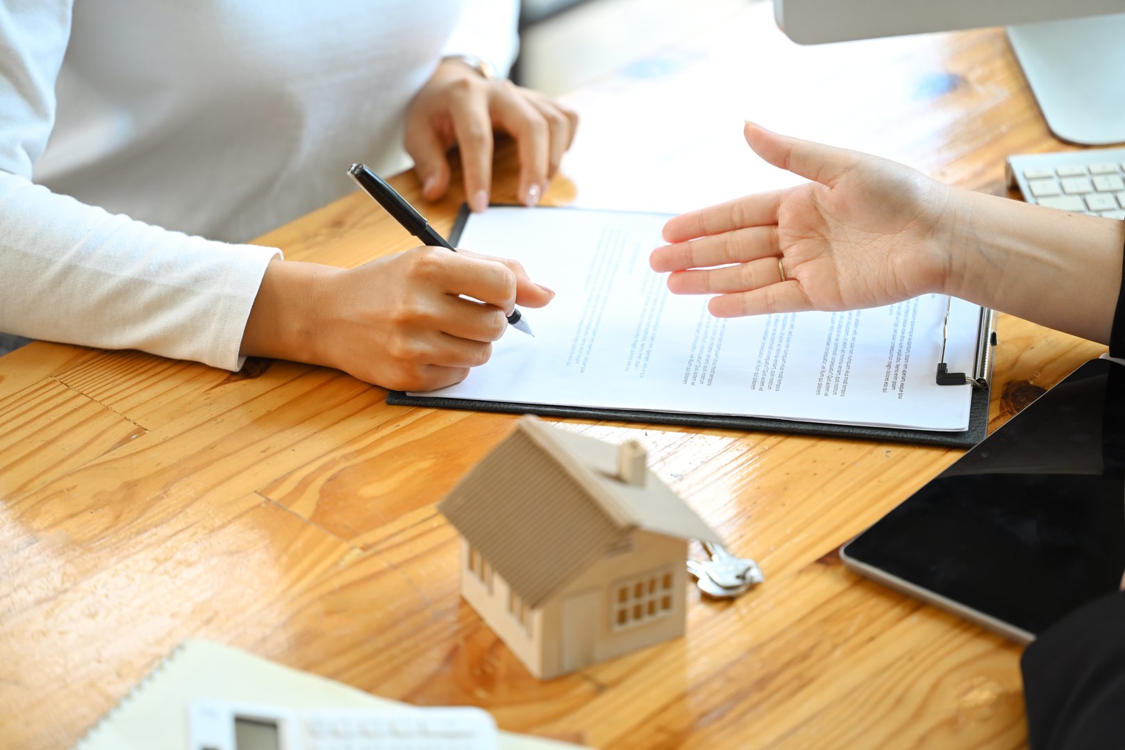 real estate agent pointing at contract document to client put a signature. Real estate and property insurance concepts.
