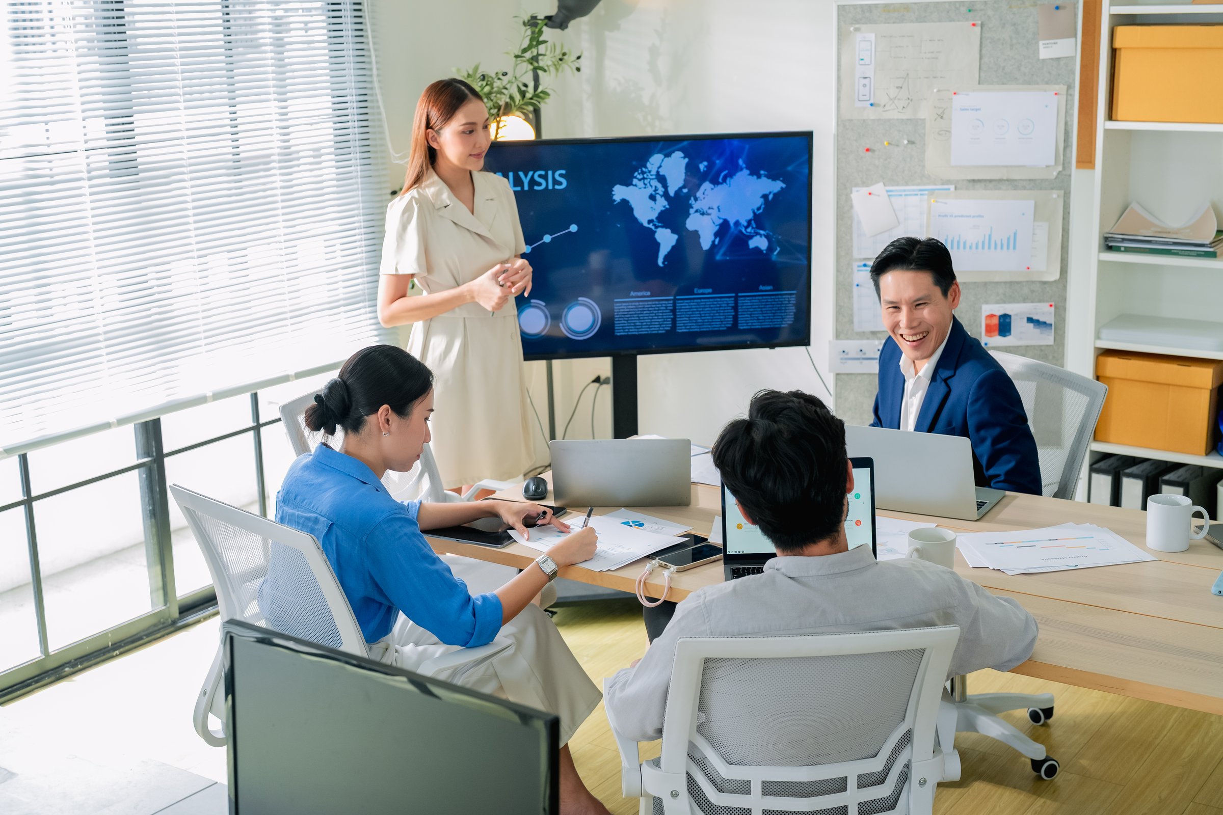 Asia strategist leader presents a financial and agile strategy plan to the team in a modern office, leading a collaborative brainstorming session to align goals, boost productivity, and ensure success