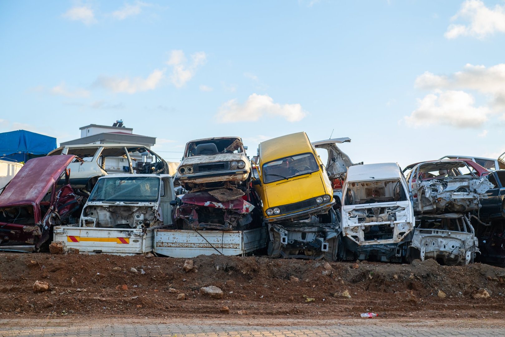 Piles of old cars in a scrap yard.