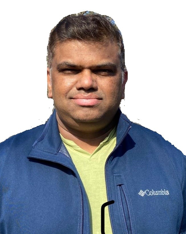 Person wearing a blue Columbia jacket and green shirt, standing outdoors against a white background.