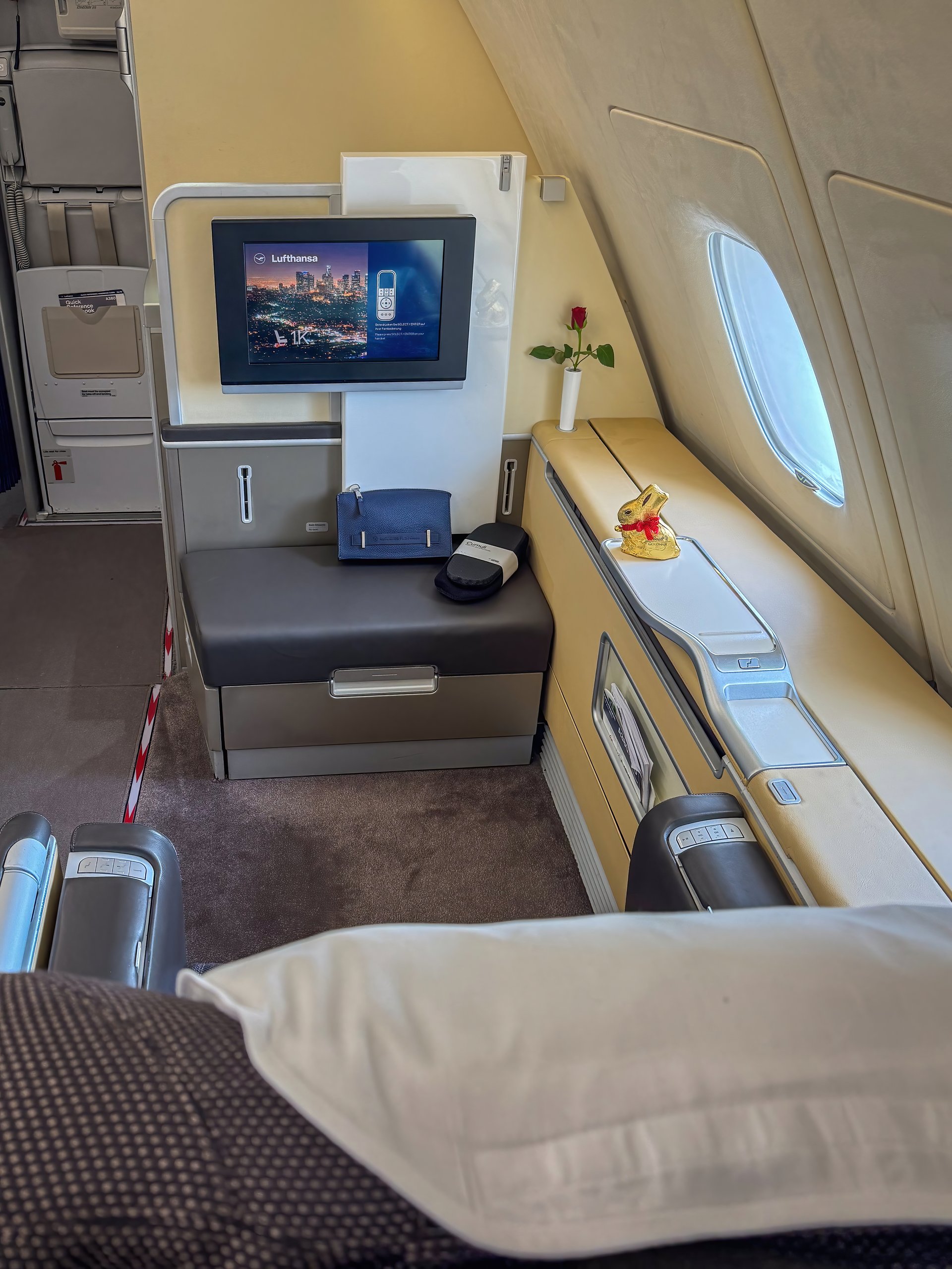 Munich, Germany - March 29, 2024: Lufthansa First Class seat 1K in an Airbus A380 with easter chocolate bunny