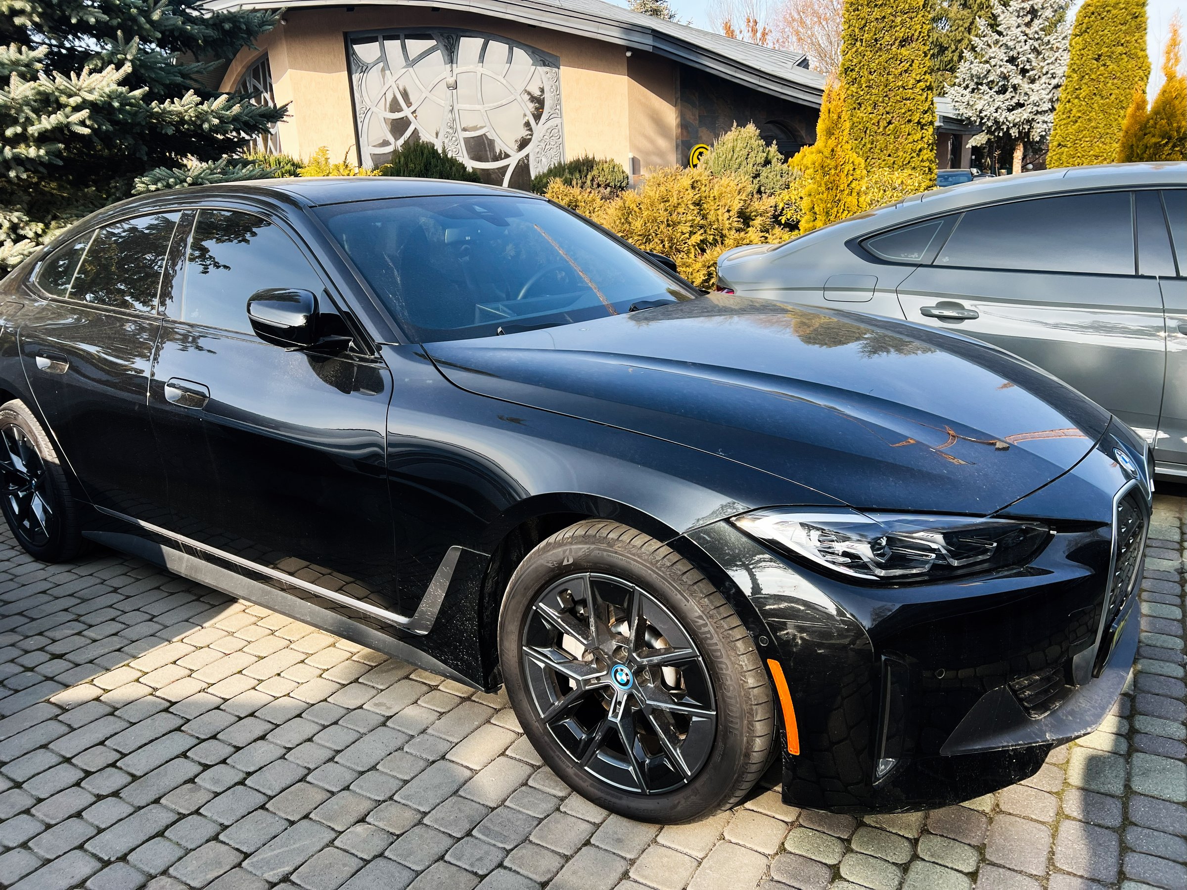 Lviv, Ukraine - February 12, 2025: Luxury black BMW i4 car parked outdoors on a sunny day in a suburban neighborhood
