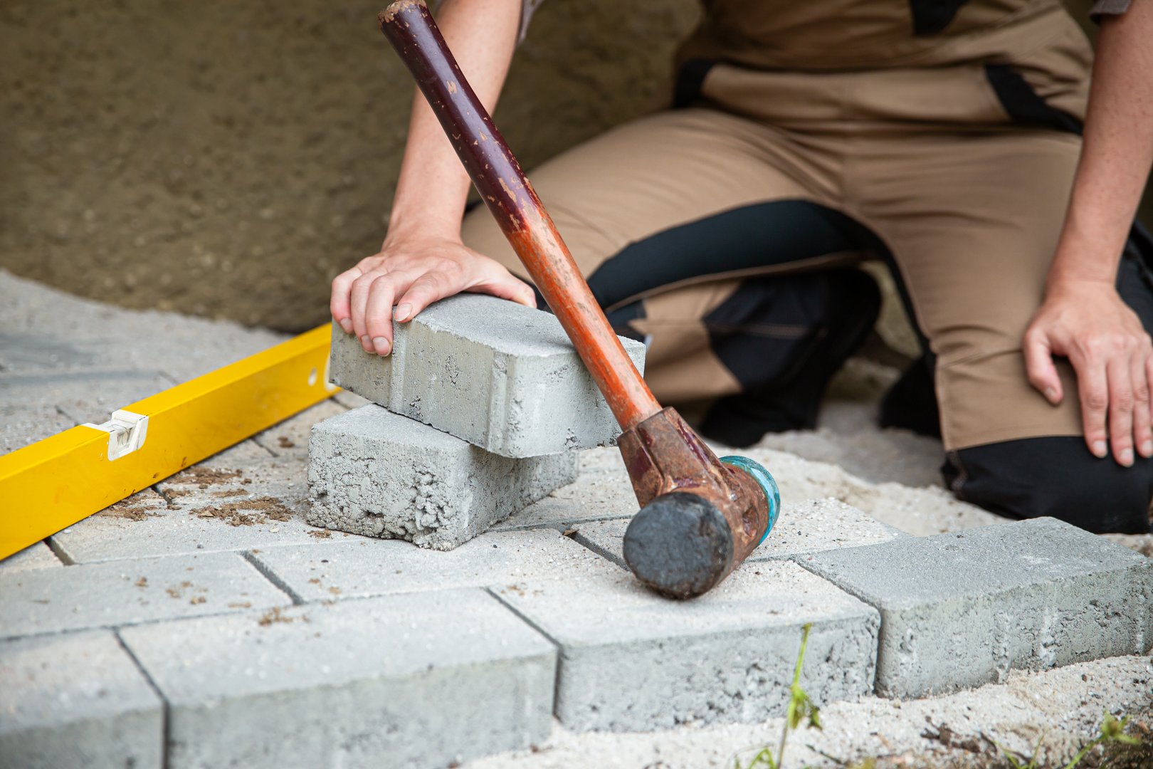 a woman lays paving stones in her garden, concept diy or craftswoman