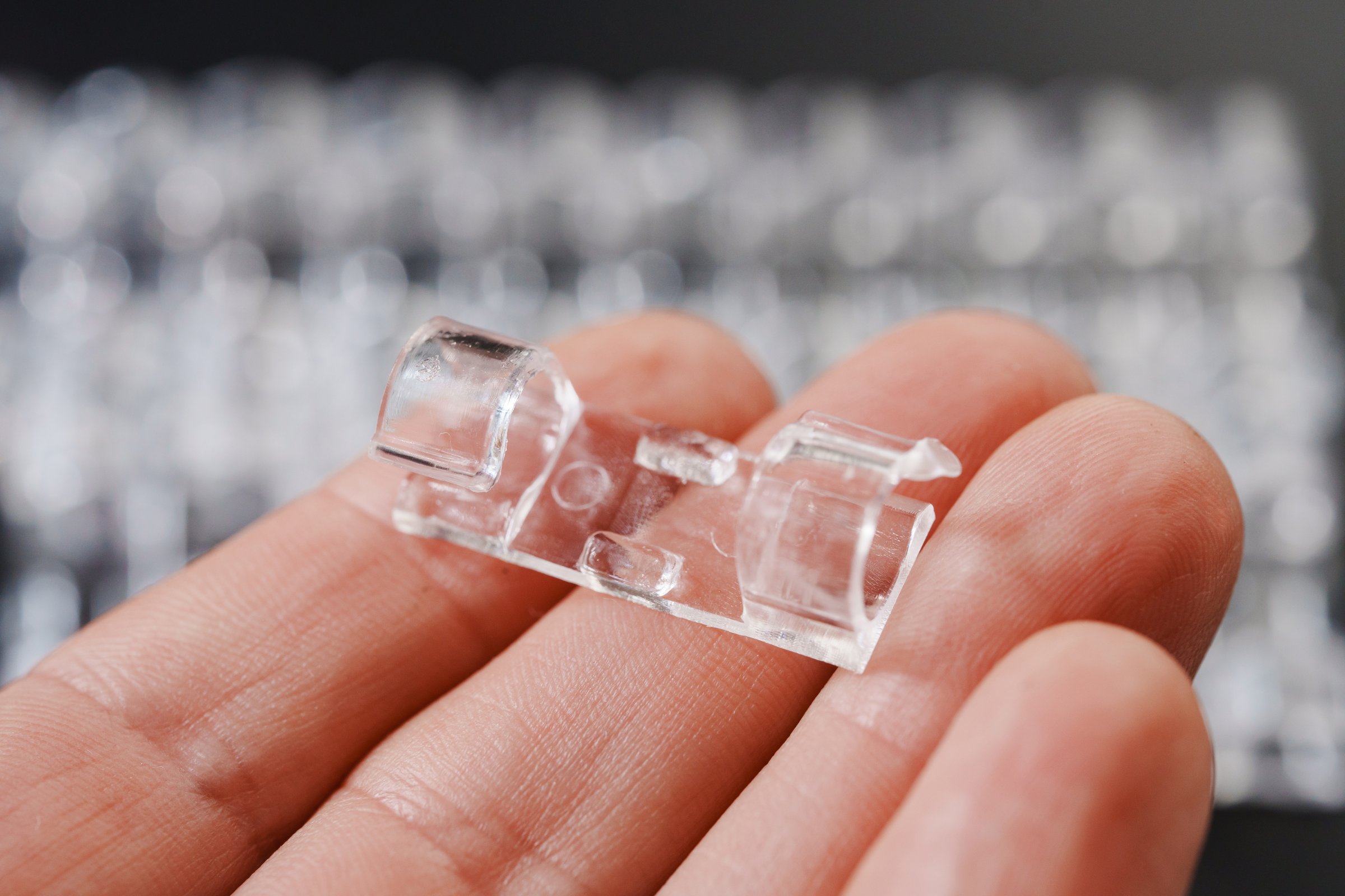 hand and clear plastic wire holders on the black surface. details for a comfortable life and aesthetics.