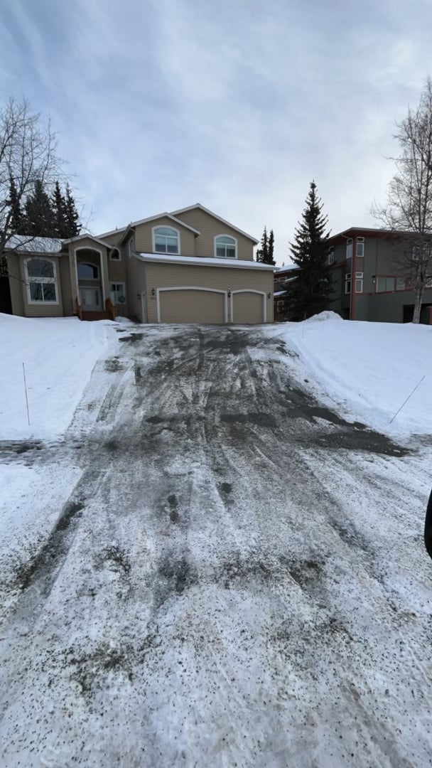 Residential driveway snow removal service showcasing cleared path and snow-covered surroundings in Anchorage, Alaska.