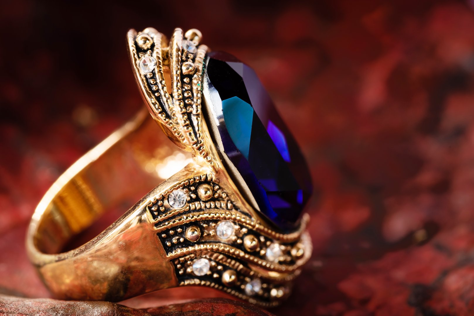 Close-up gold ring and blue gem and dimond jewelry  on leaf  background.Vintage ring,ancient jewelry,used for vintage fashion background
