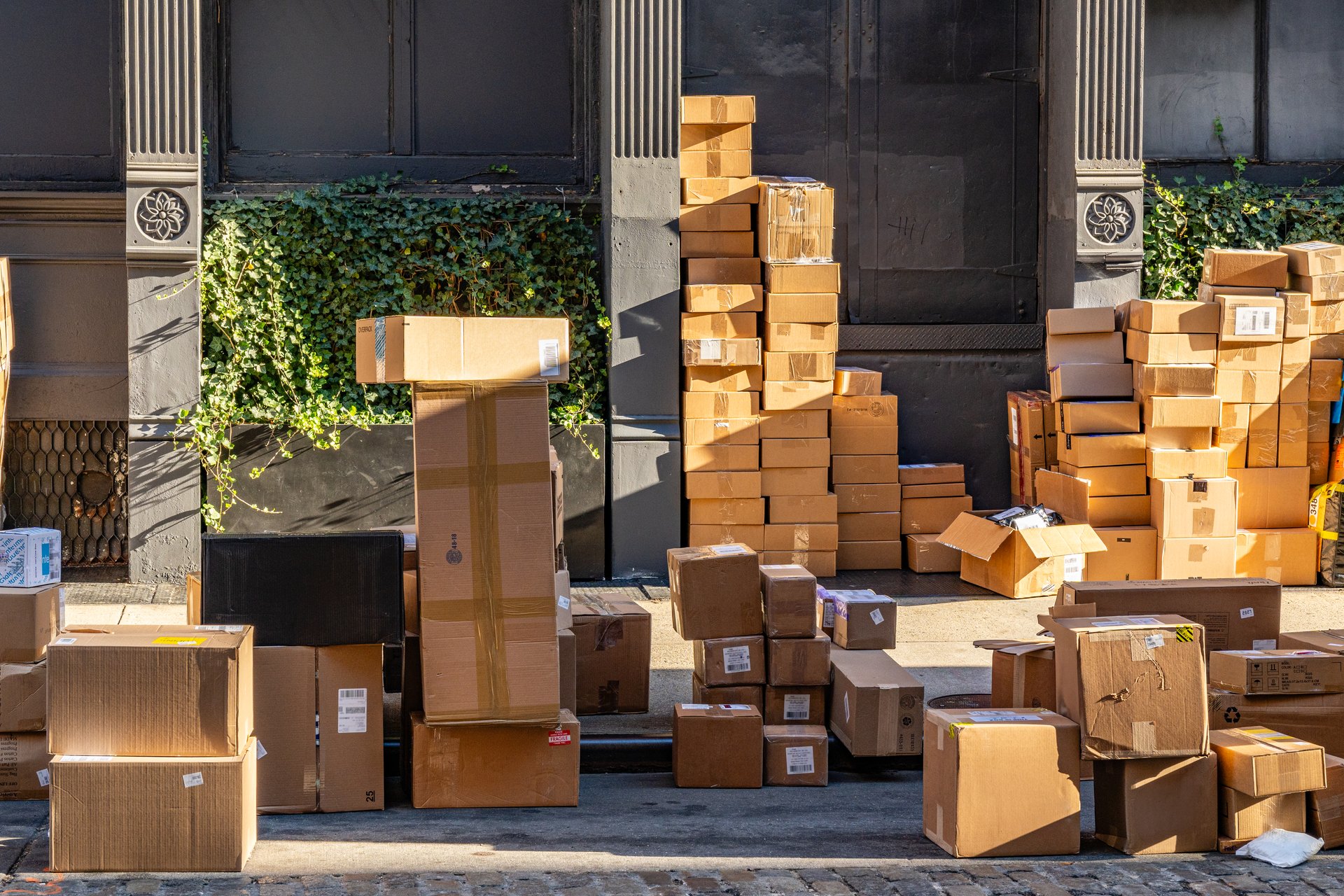 New York, NY, US-November 15, 2024: Many tall  piles of packages being delivered on city street on sunny day.