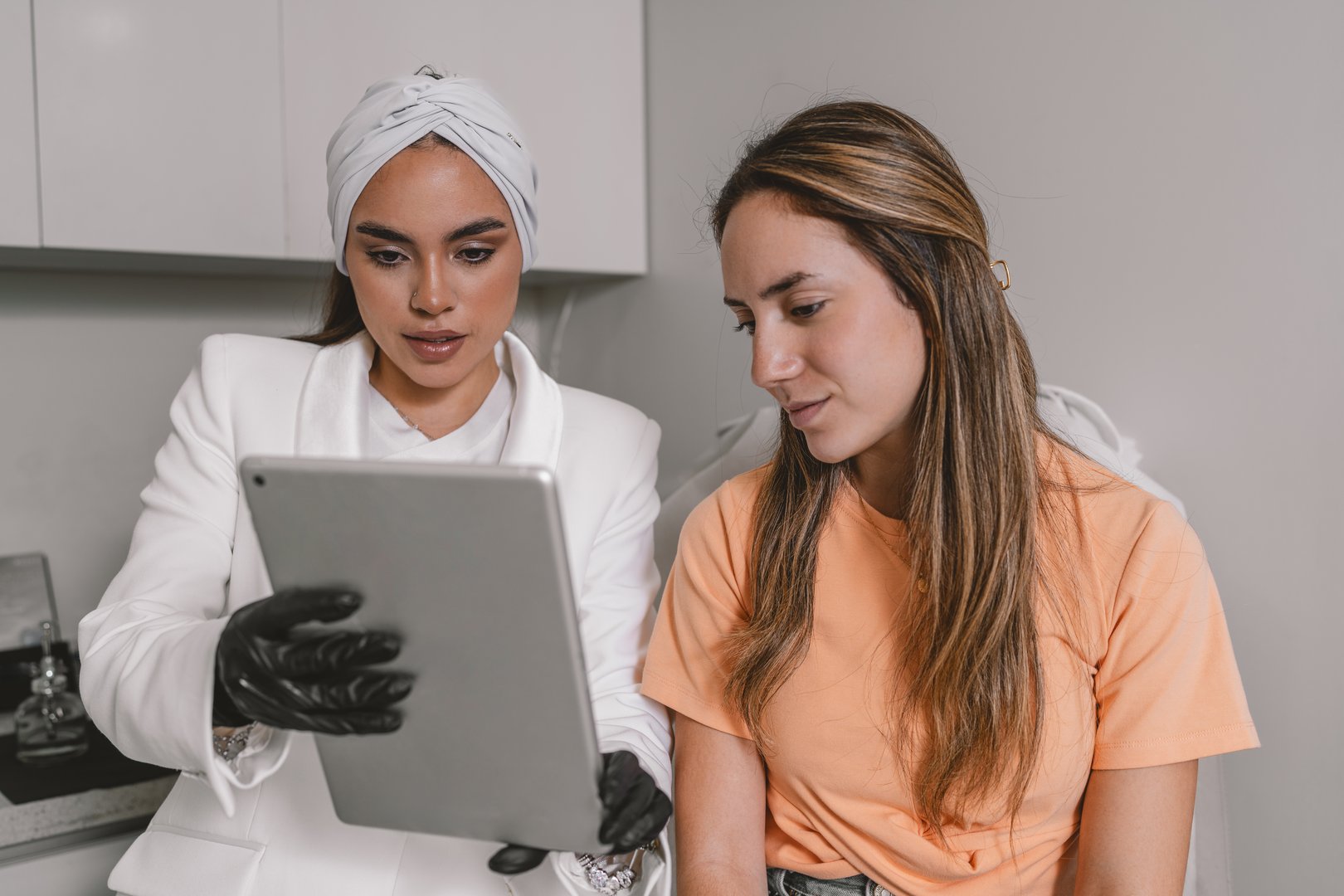 Doctor using digital tablet to explain a beautician treatment to a patient