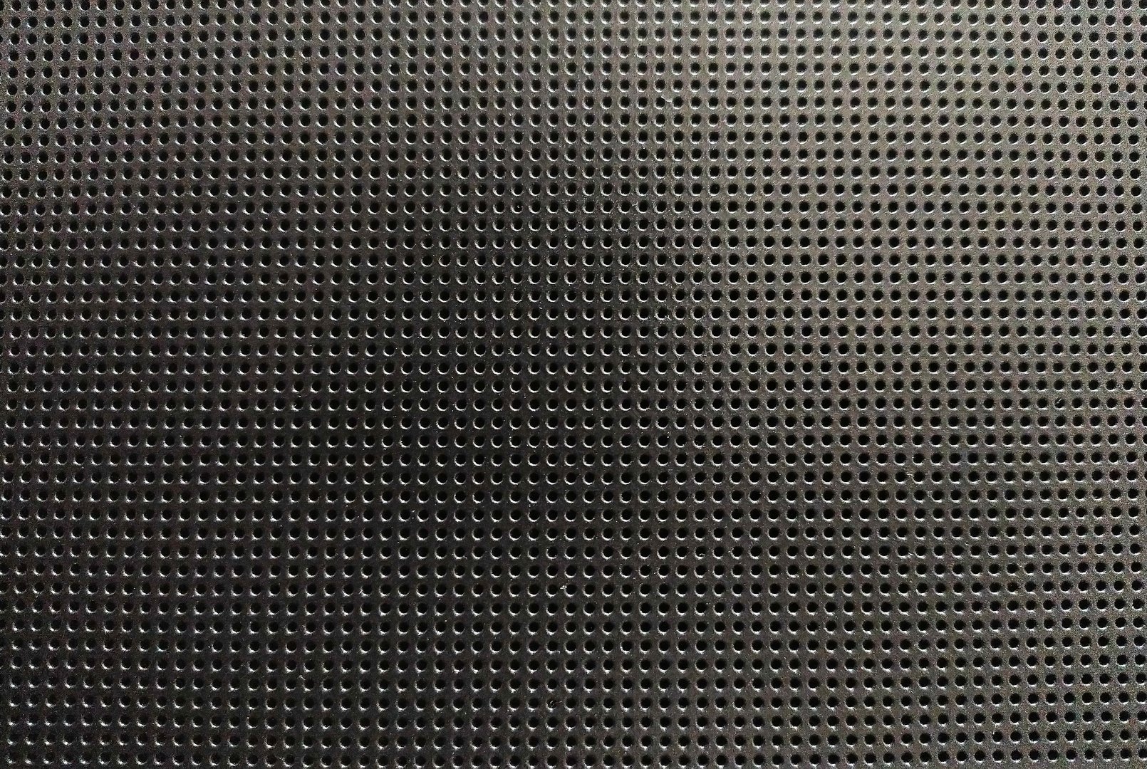 Sleek perforated metal surface. A modern and industrial background texture, perfect for technology, design, or architectural applications. Versatile, uniform pattern.