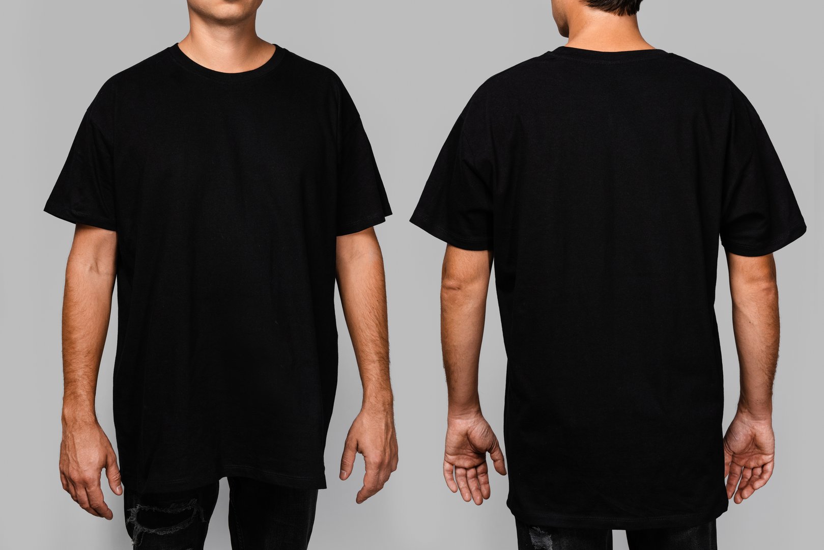 Front and back views of a man wearing a black, oversized t-shirt with blank space, ideal for a mockup, set against gray background.
