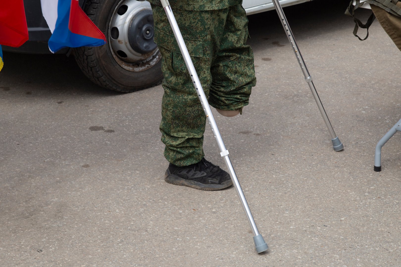 A young man with a war disability without one leg on crutches