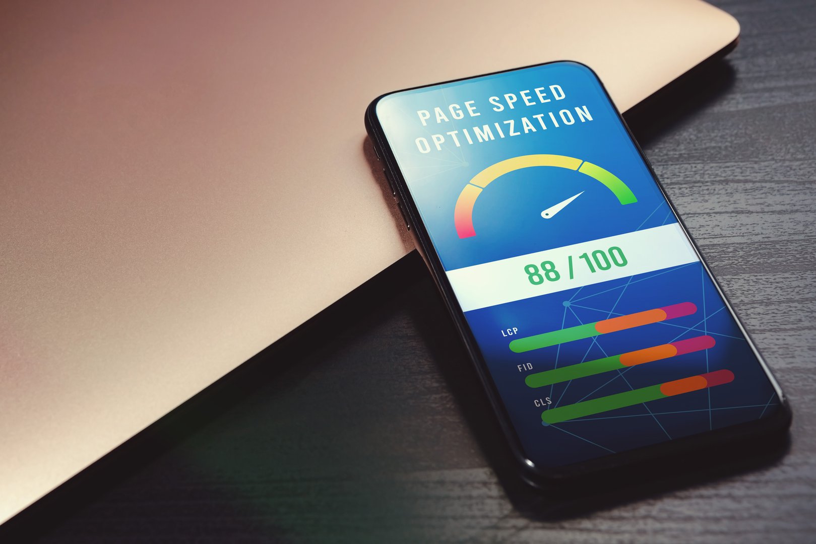 Boost mobile website performance with page speed optimization. Core Web Vitals - LCP, FID, CLS. High-value accelerometer on phone screen beside laptop on wooden table for SEO digital marketing visuals
