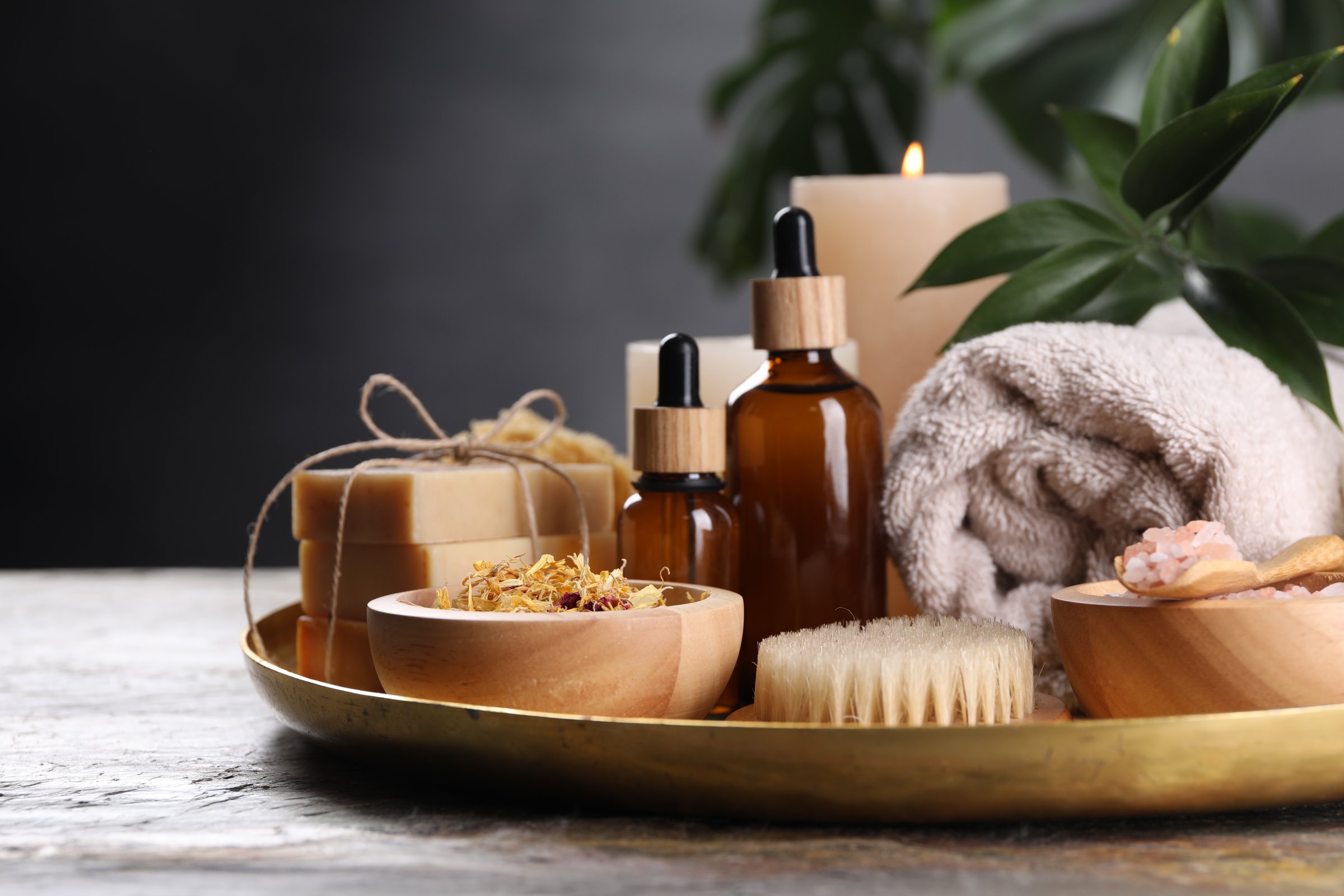 Spa composition. Dry flowers, bottles and soap bars on table, closeup