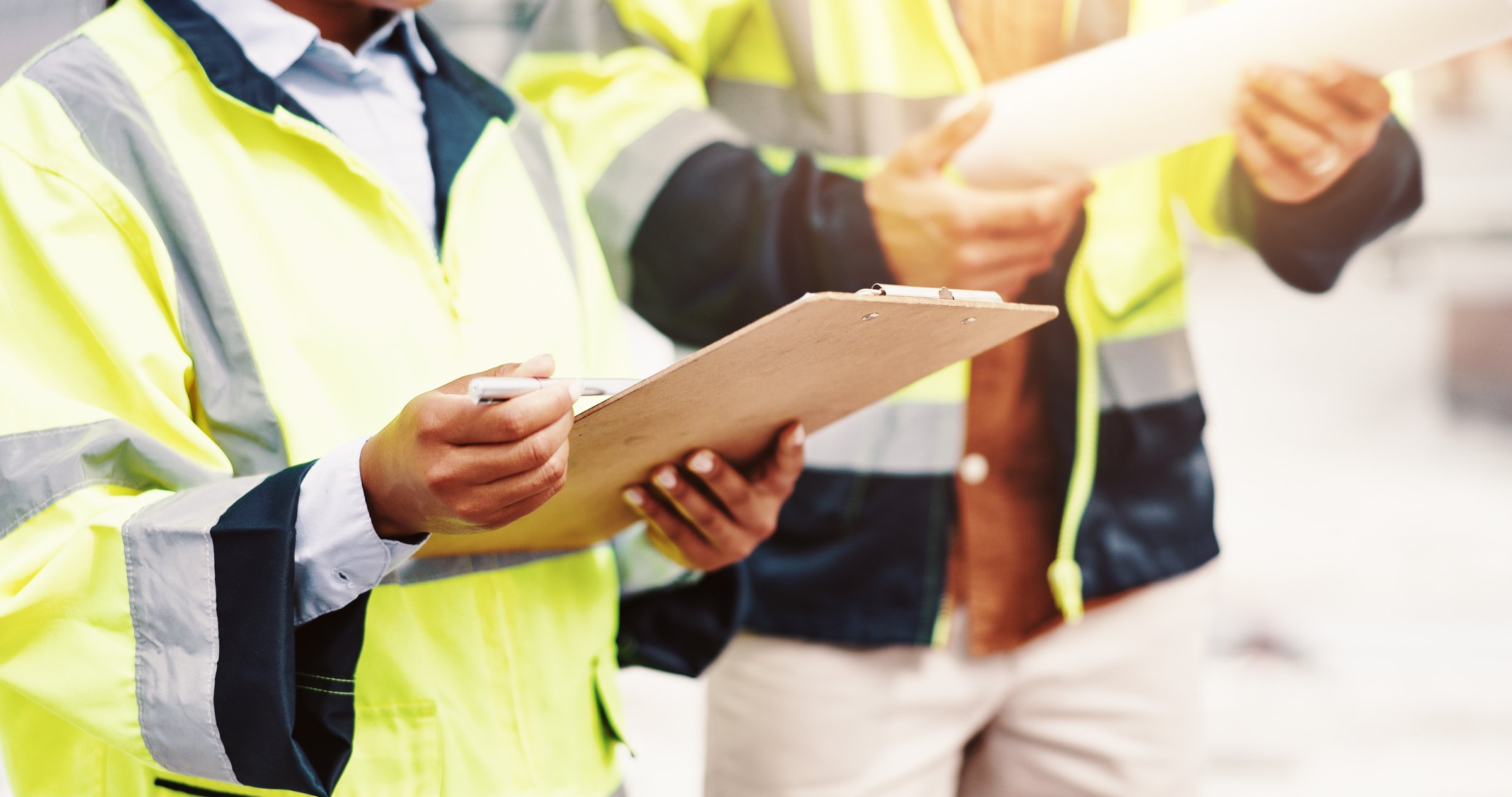 People, clipboard or hands with architect for construction checklist, inspection or planning in city. Closeup, civil engineer or contractors with document for building layout, project or safety check